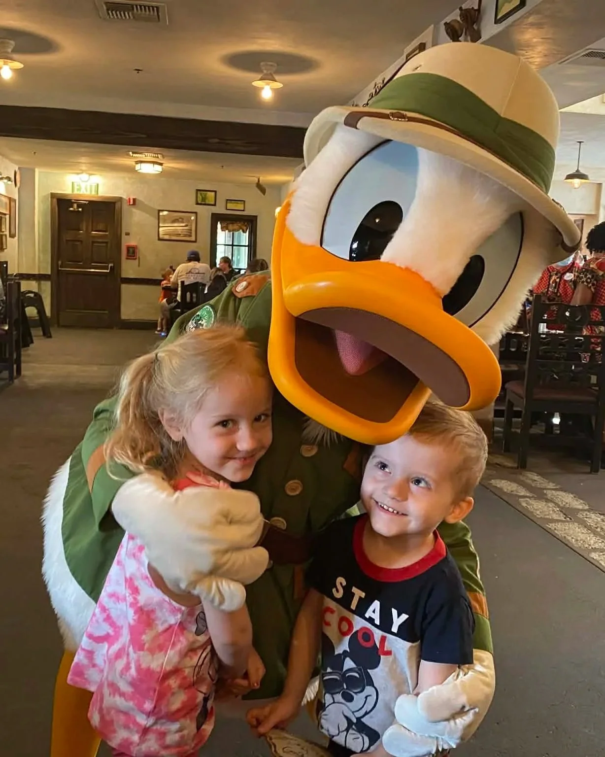 Costumed character of Donald Duck with children in a restaurant.