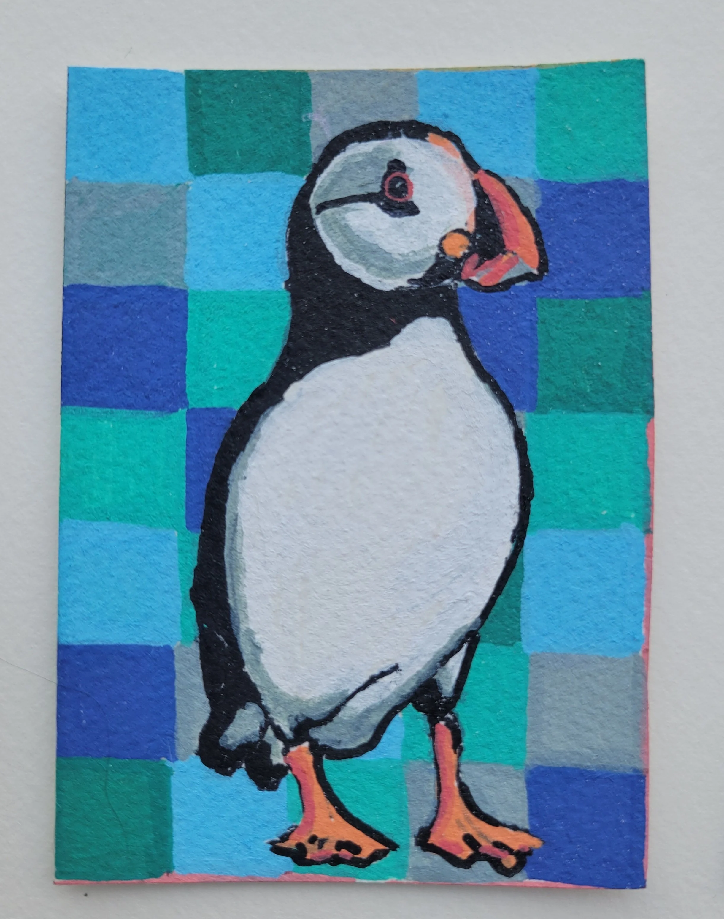 Colorful painting of a puffin bird standing against a checkered blue and green background.