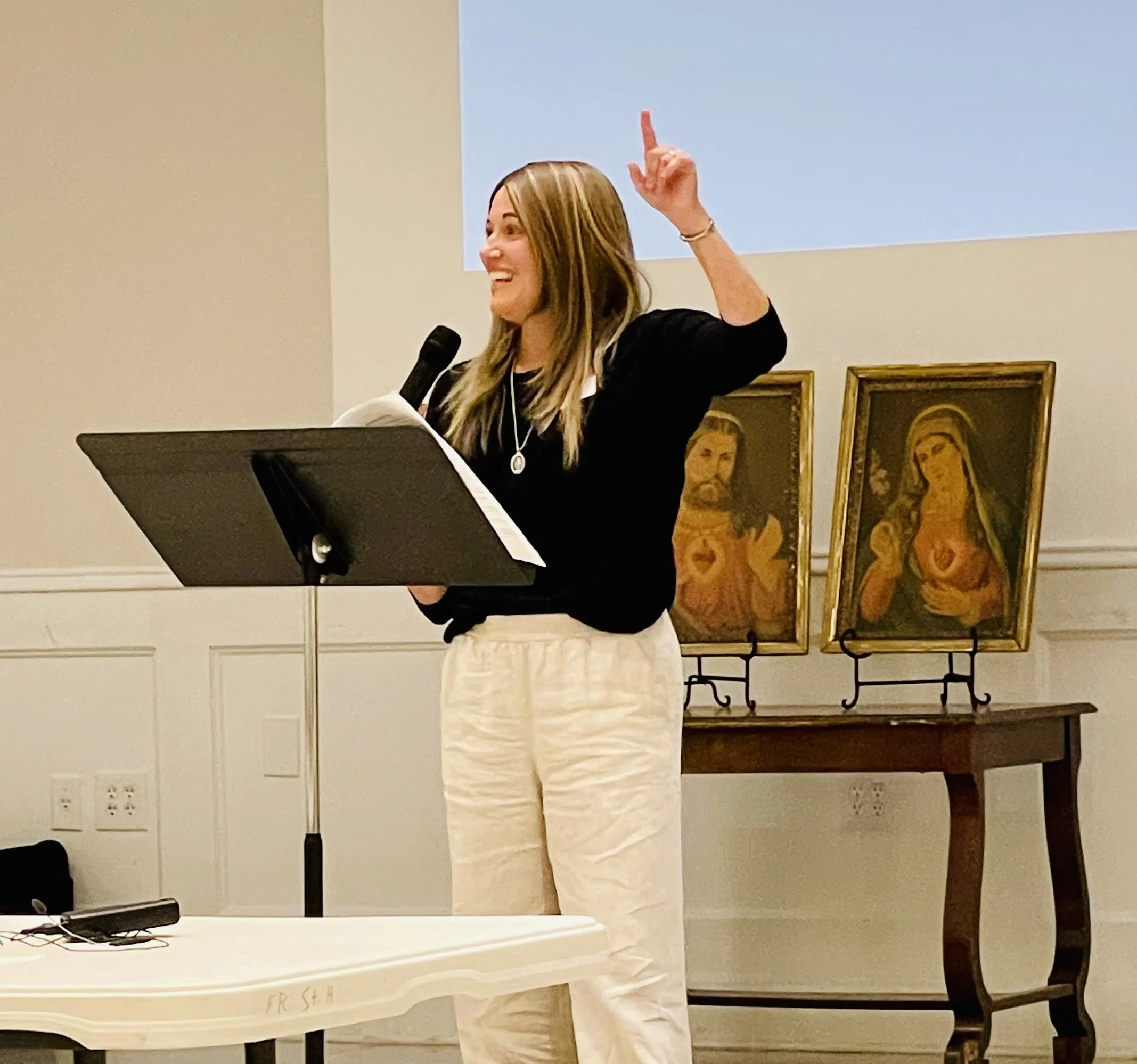 Author Julie Yost teaching in front of images of Jesus and Mary.