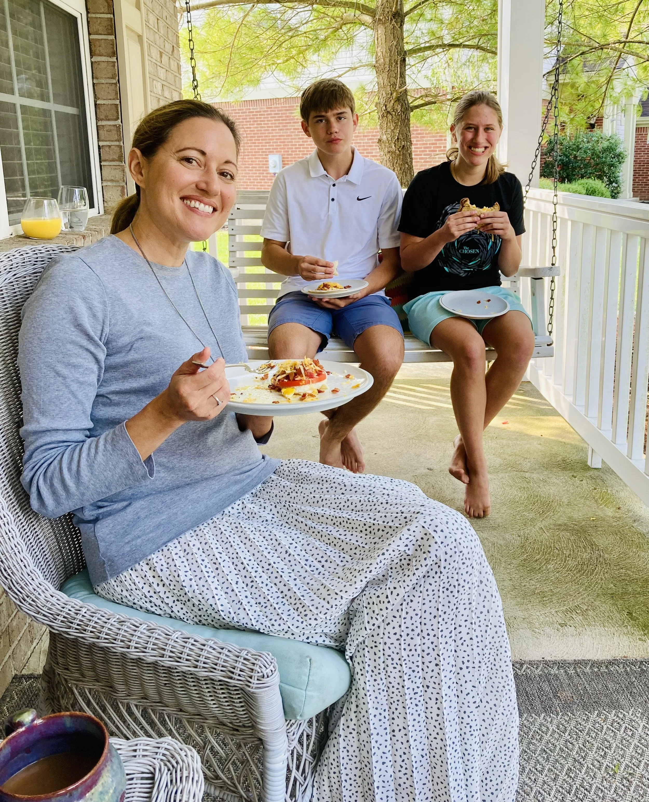 Author Julie Yost sitting with her children on a porch.