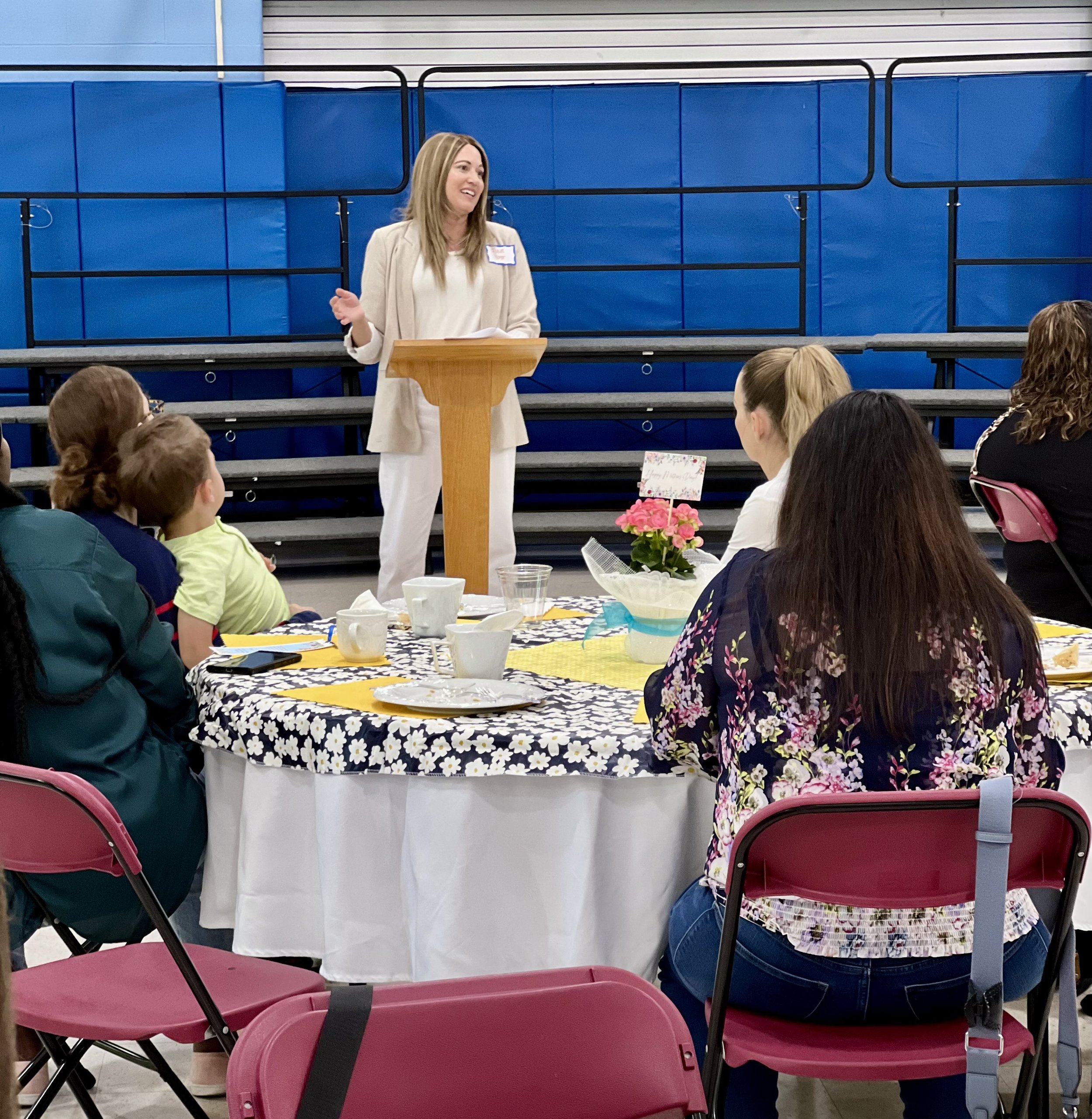 Author Julie Yost speaking at a podium in front of a seated audience.
