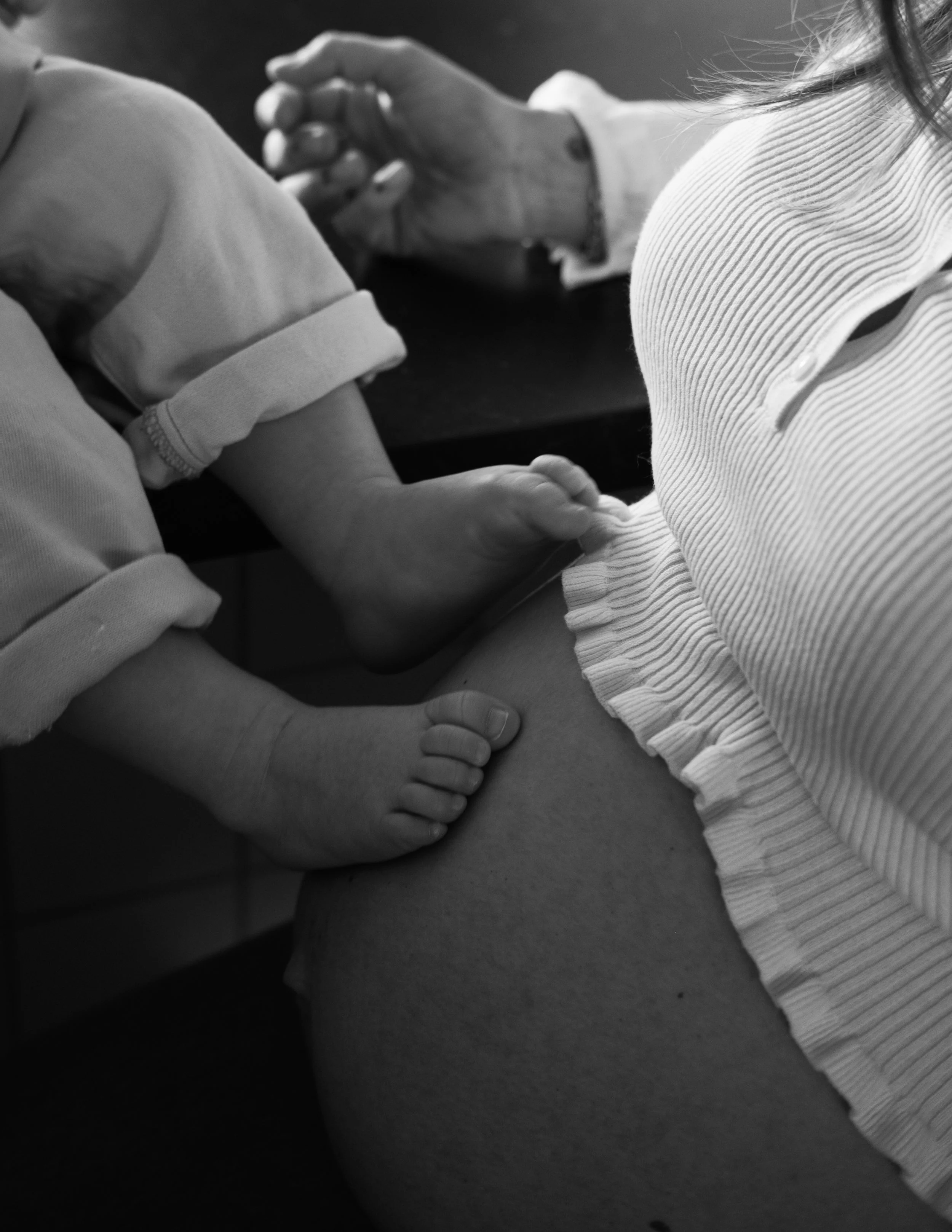 A black and white photo of a person holding a child's arm while administering a vaccination or injection to the child's upper arm.
