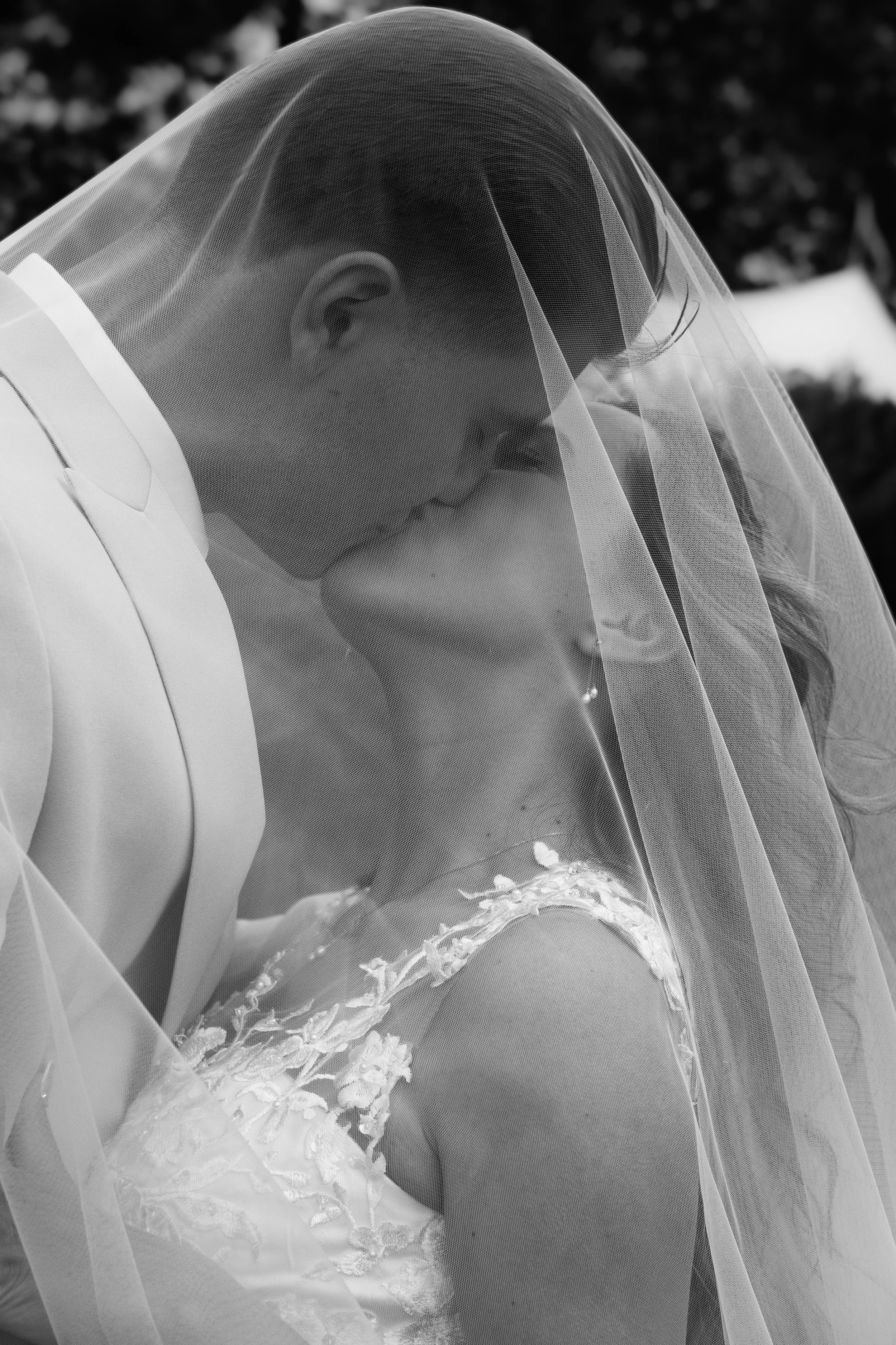 Bride in a wedding dress with lace details and a sheer veil.