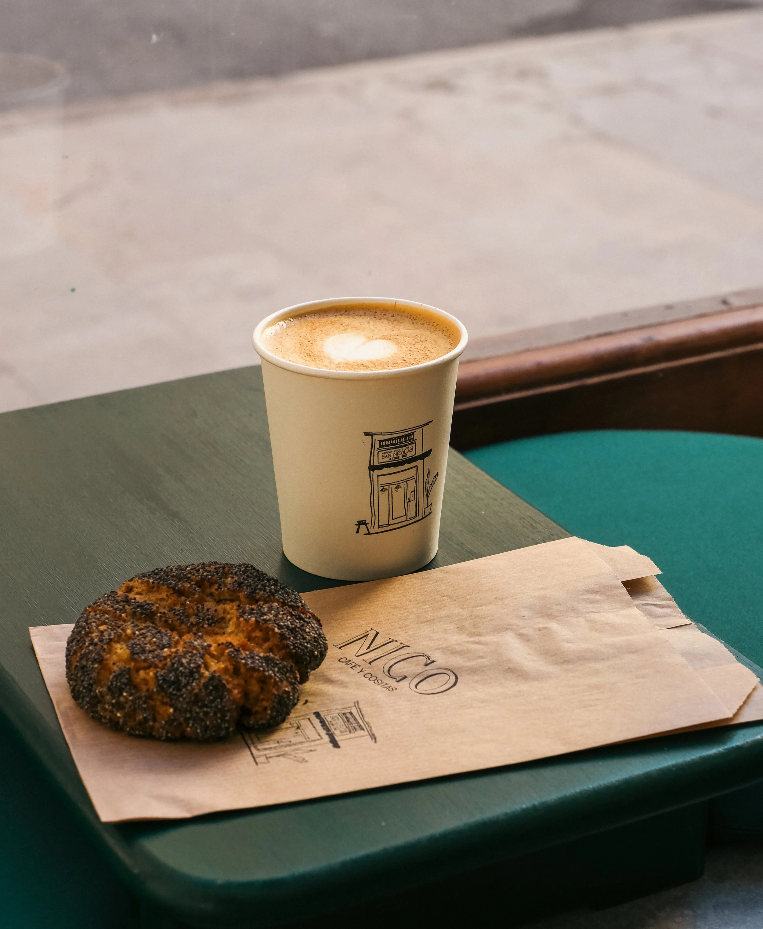 Coffee and cookie on a green bench in Valencia
