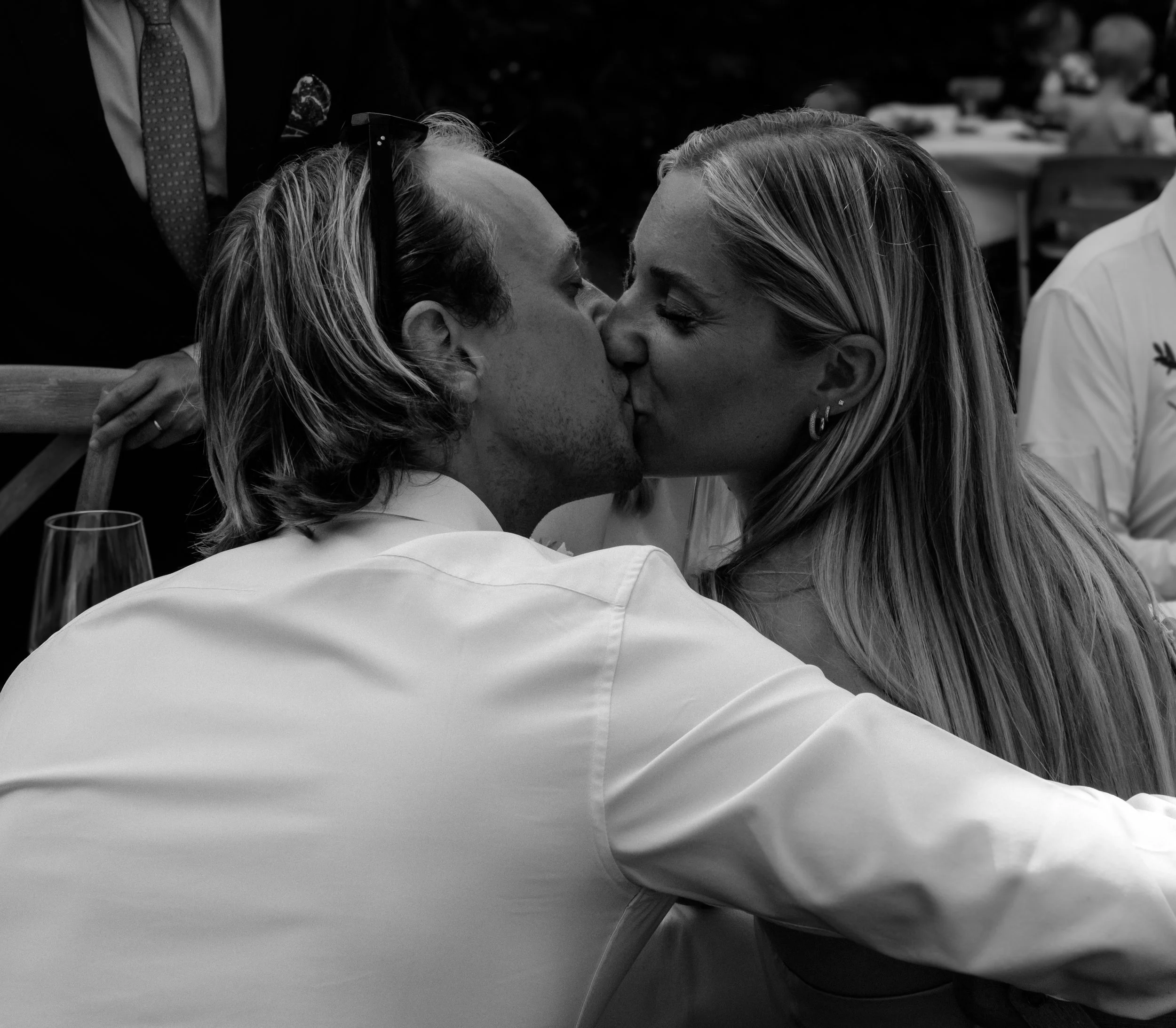 A black-and-white photo of two women close together, about to kiss, showing their faces and hairstyle details.