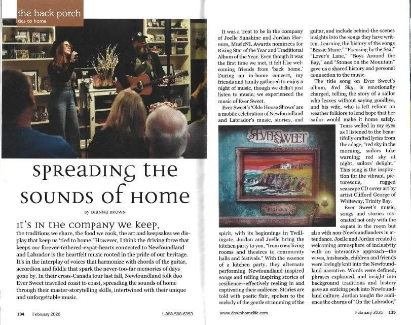 Photo of musical performers playing guitar and singing in a cozy indoor setting, with an audience in the foreground. The image is part of a magazine article about music and home.