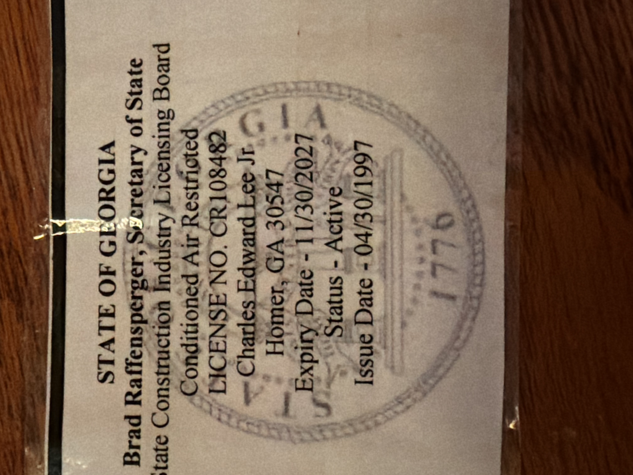 Close-up of a certification or official document with a circular stamp, partially visible, including text and signature.