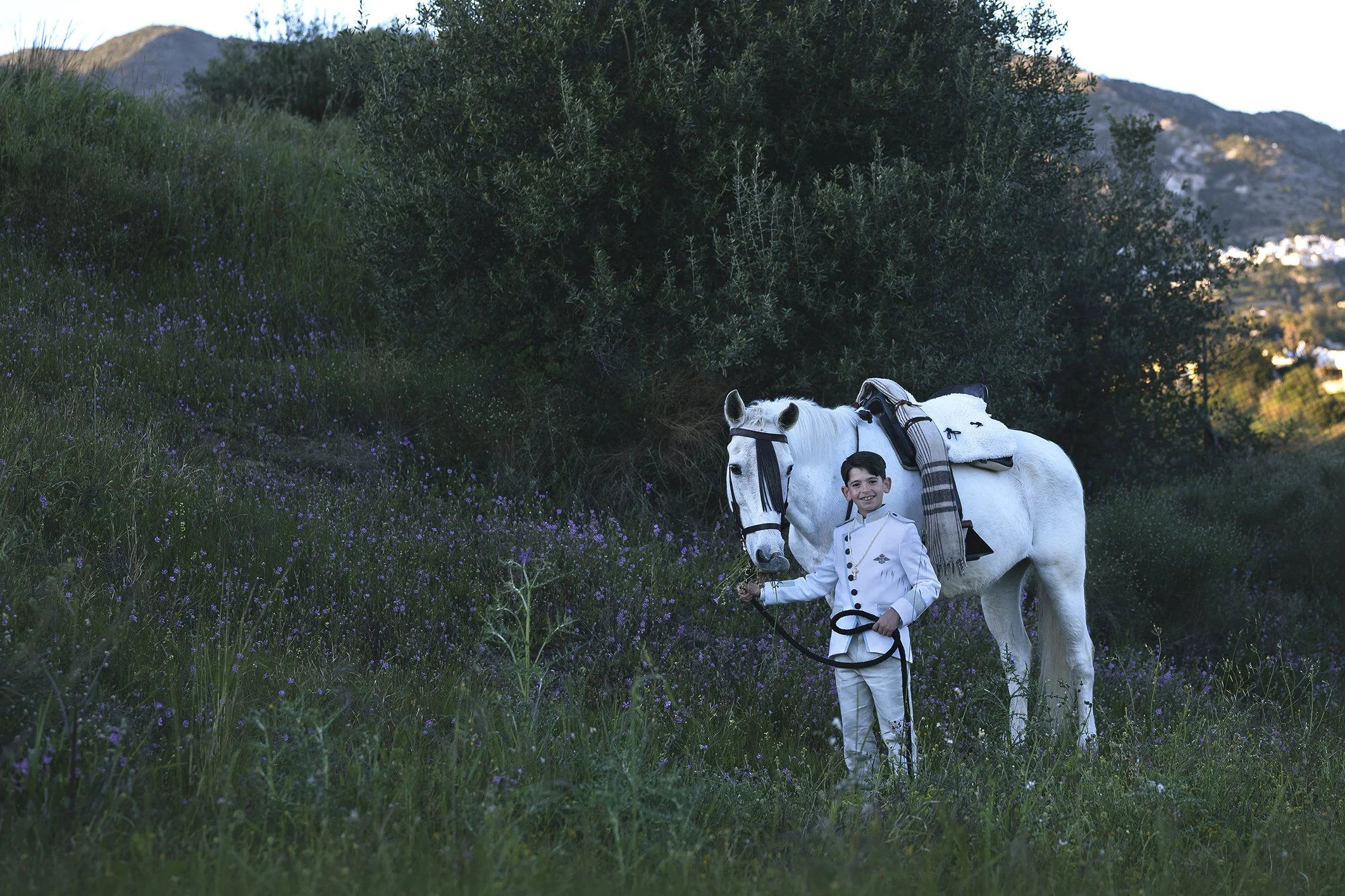 Niño y su caballo posando para una sesión de fotos de comunion en un bosque en Mijas