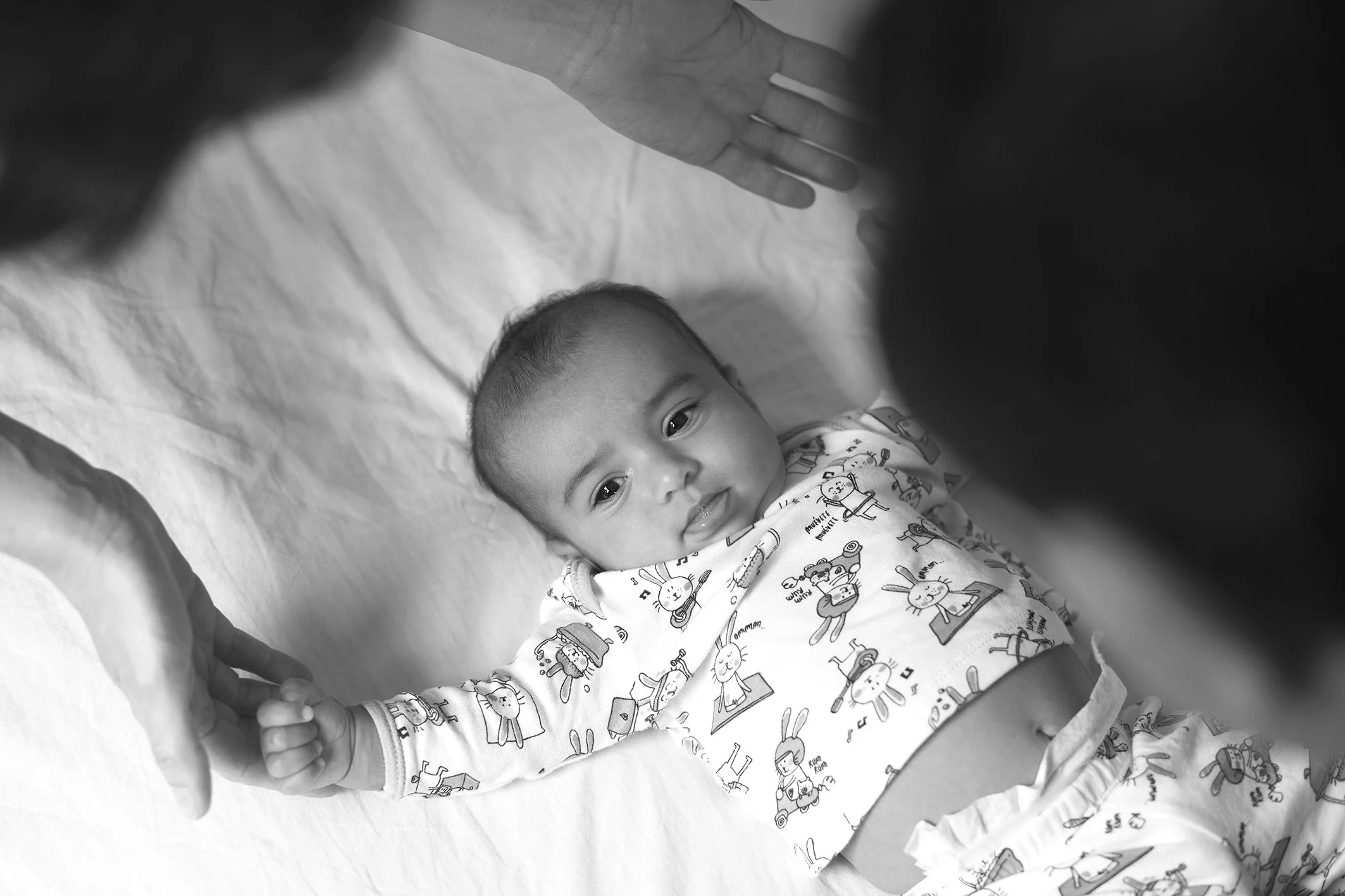 bebé estirándose comodamente en su cama en una sesión de fotos profesional estilo lifestyle