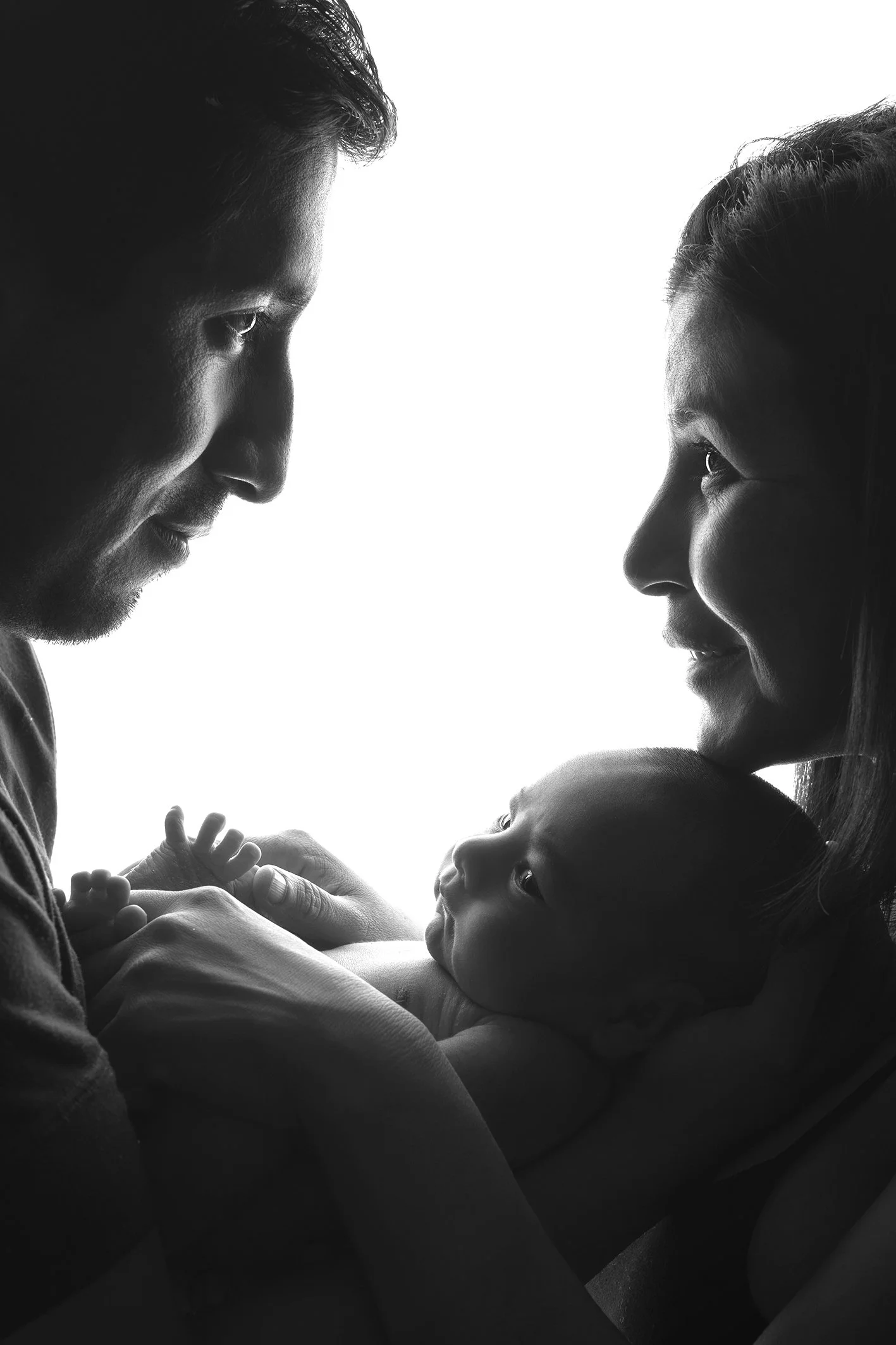 familia sonriendo al rededor de su bebé recién nacido en una sesión de fotos en Torremolinos