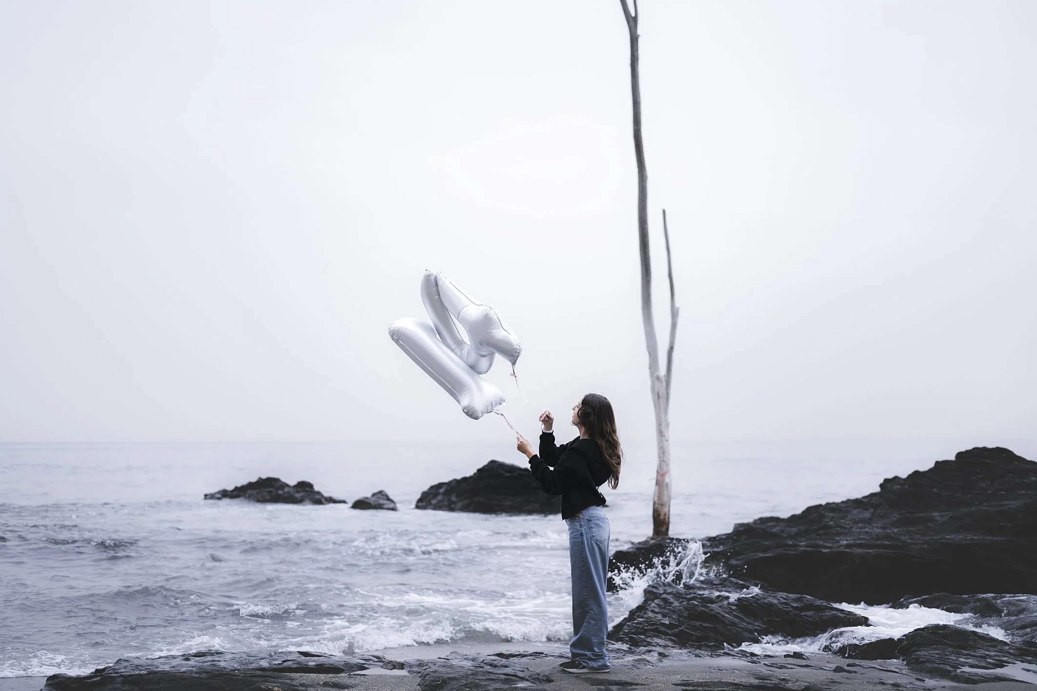 niña sosteniendo globos de cumpleaños con el número 14 junto a la playa de la Vivorilla en Benalmádena 