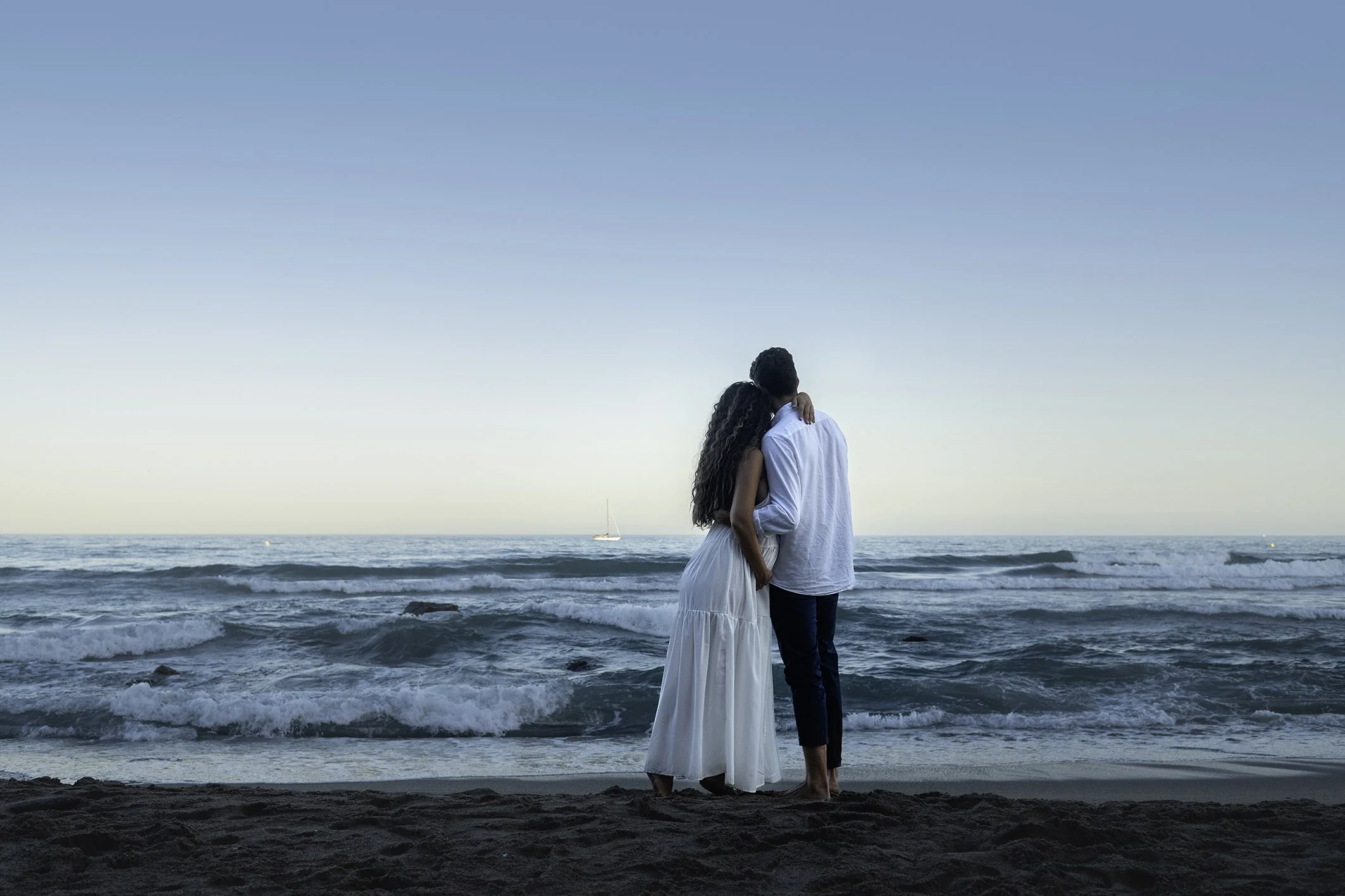 Pareja contemplando el mar mientras hace su reportaje de fotos de embarazo en Benalmádena 