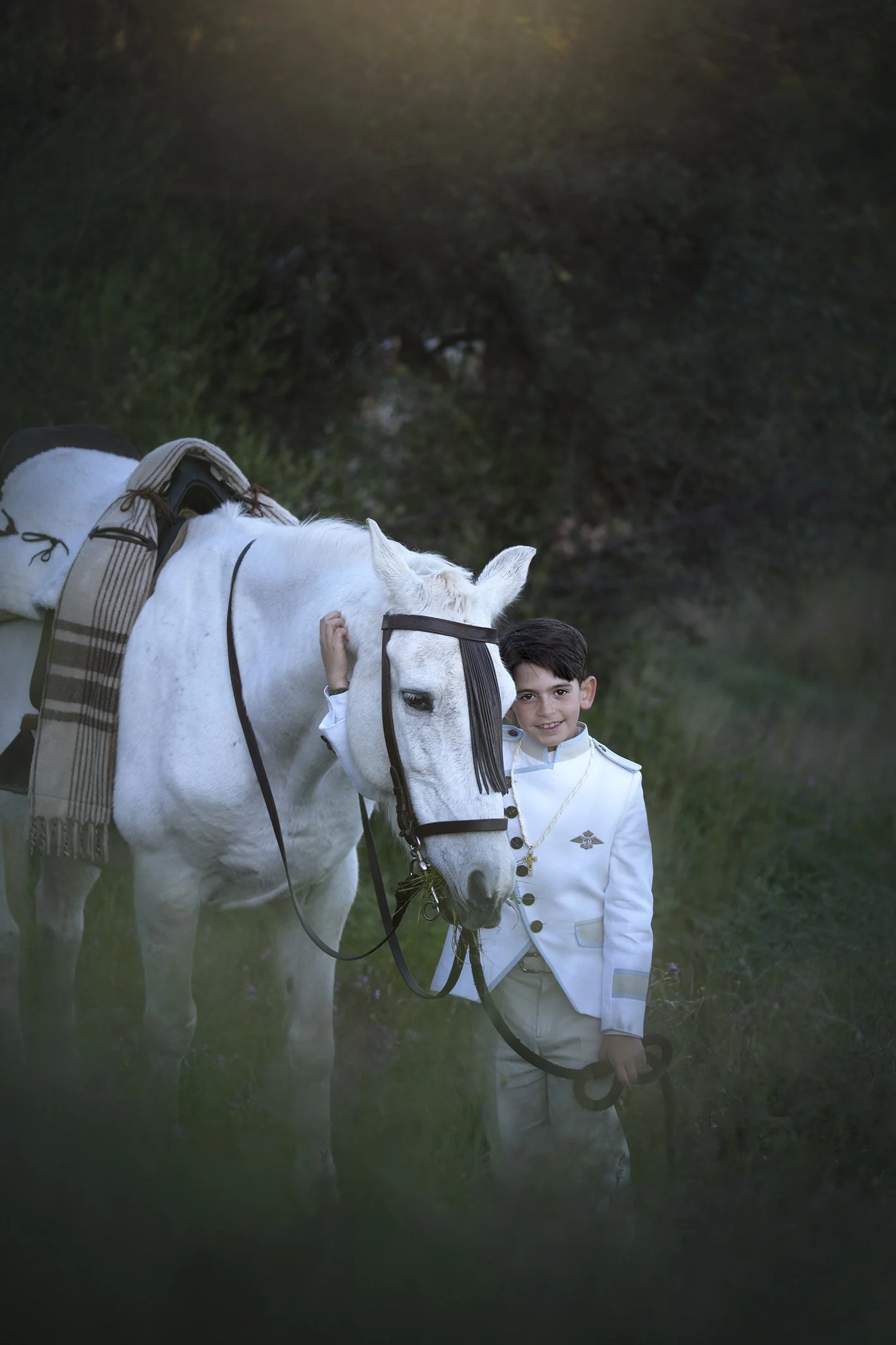 Niño y su caballo posando para una sesión de fotos de comunion en un bosque en Fuengirola España