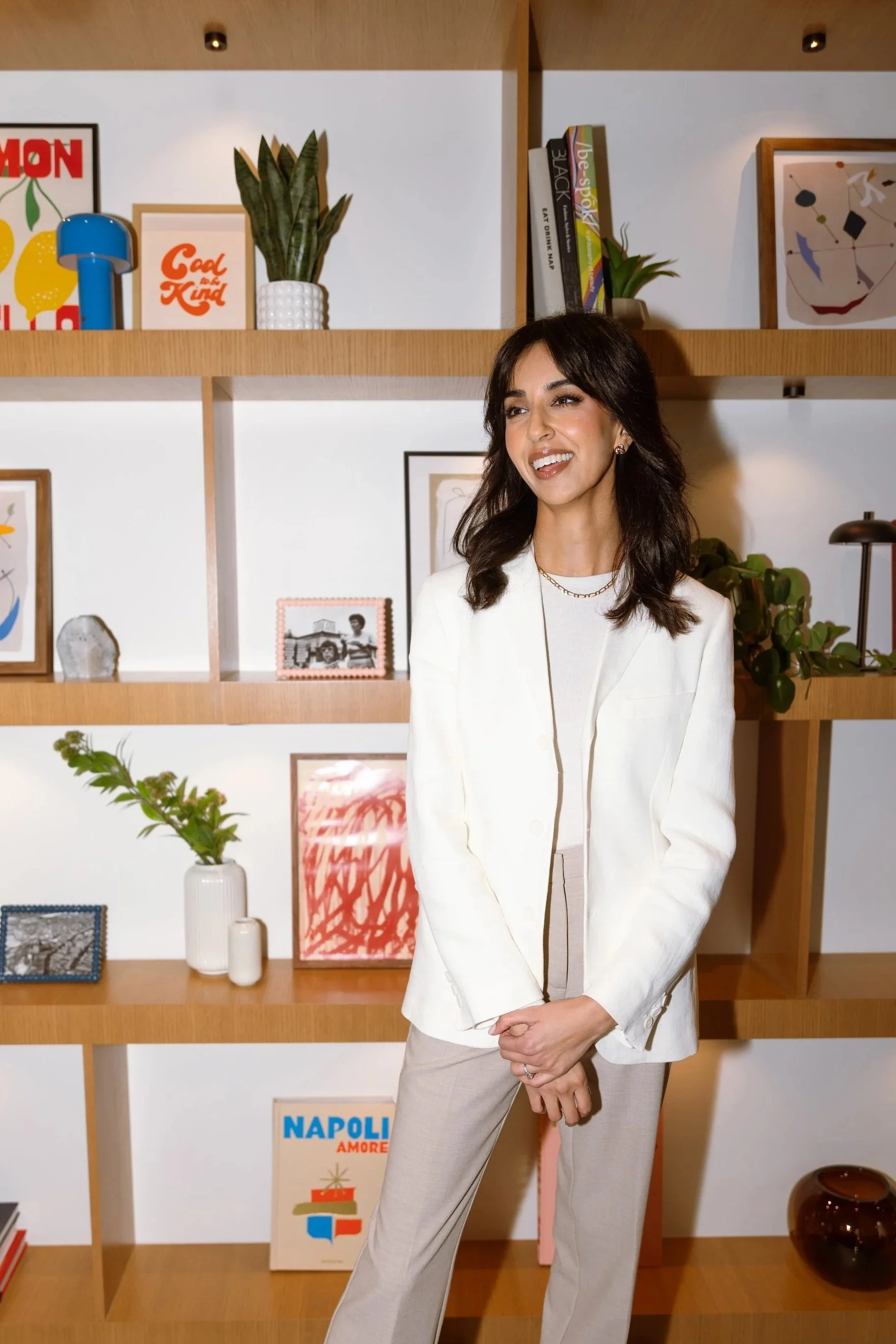 A smiling woman in front of a decorative bookshelf