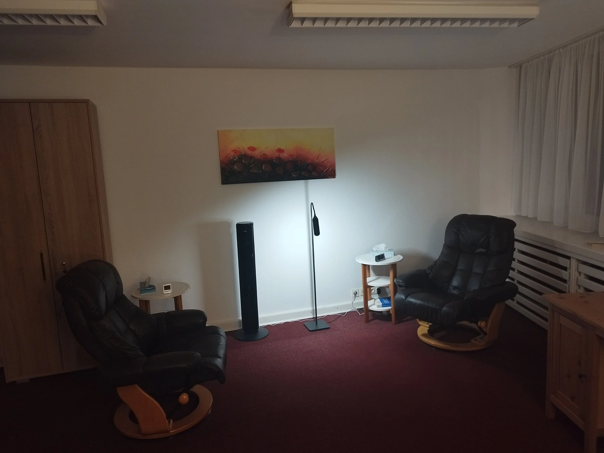Therapieraum in meiner Psychotherapiepraxis in Bremen mit zwei Therapiesesseln, Stehlampe und Bild an der Wand in ruhiger Atmosphäre
