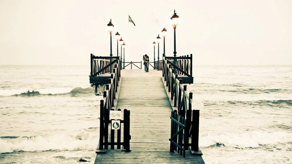 Paar am Ende eines Stegs im Meer als Symbol für Nähe und Entwicklung in der Sexualtherapie in der Psychotherapiepraxis von Svetlana Kess in Bremen