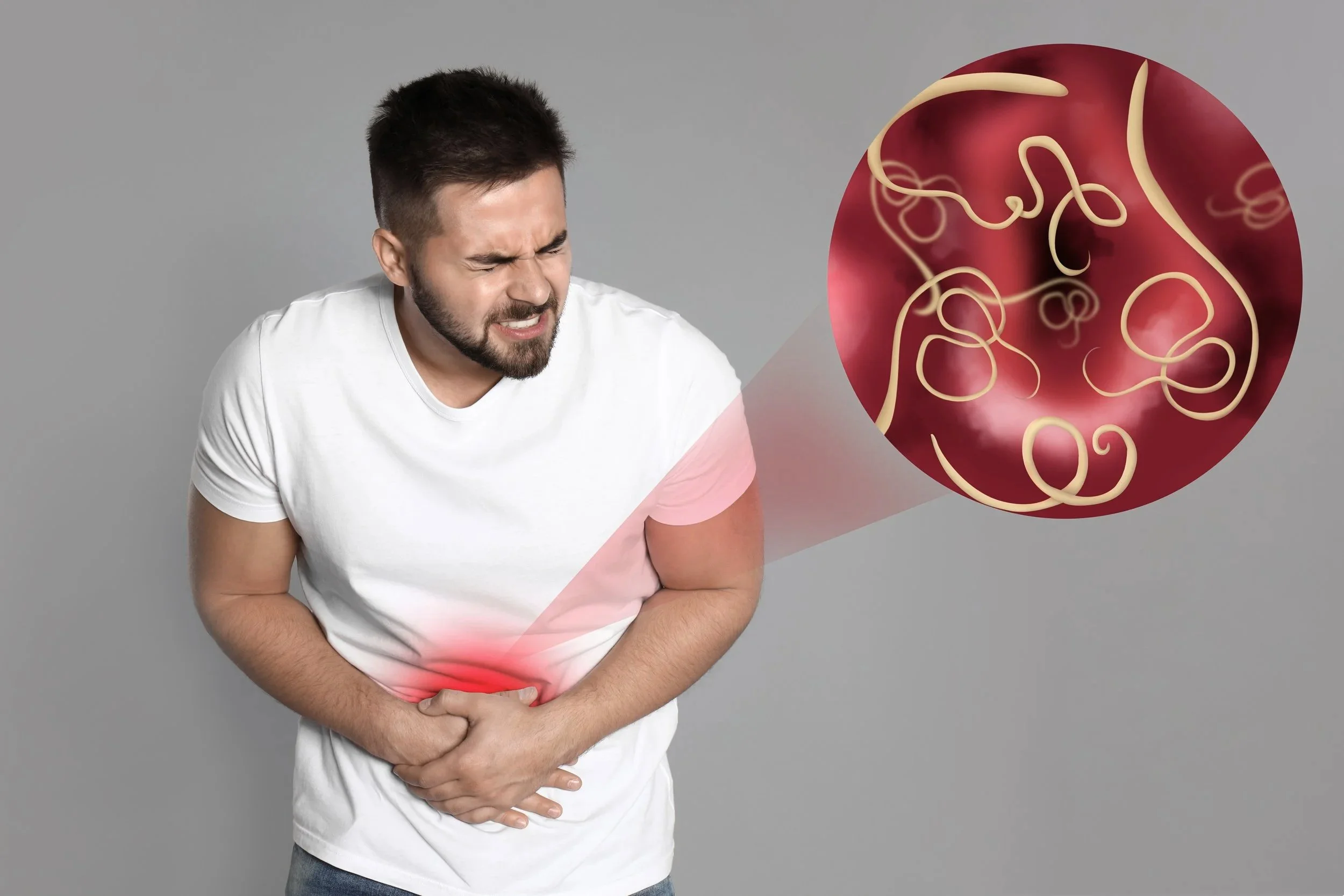 A man holding his stomach in pain with an illustrated representation of stomach pain or digestive discomfort next to him.