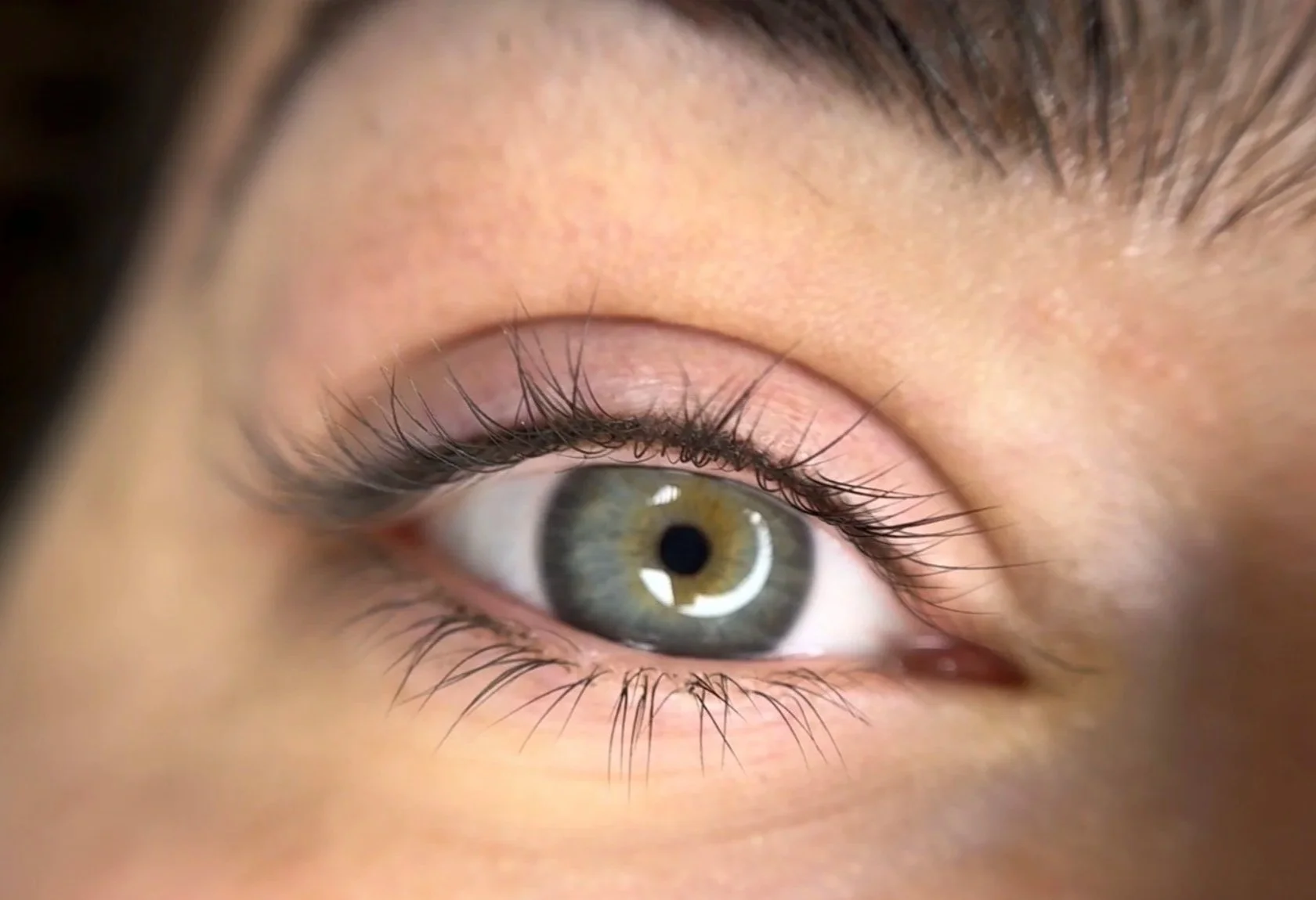 Close-up of a person's eye with detailed view of iris, eyelashes, and surrounding skin.