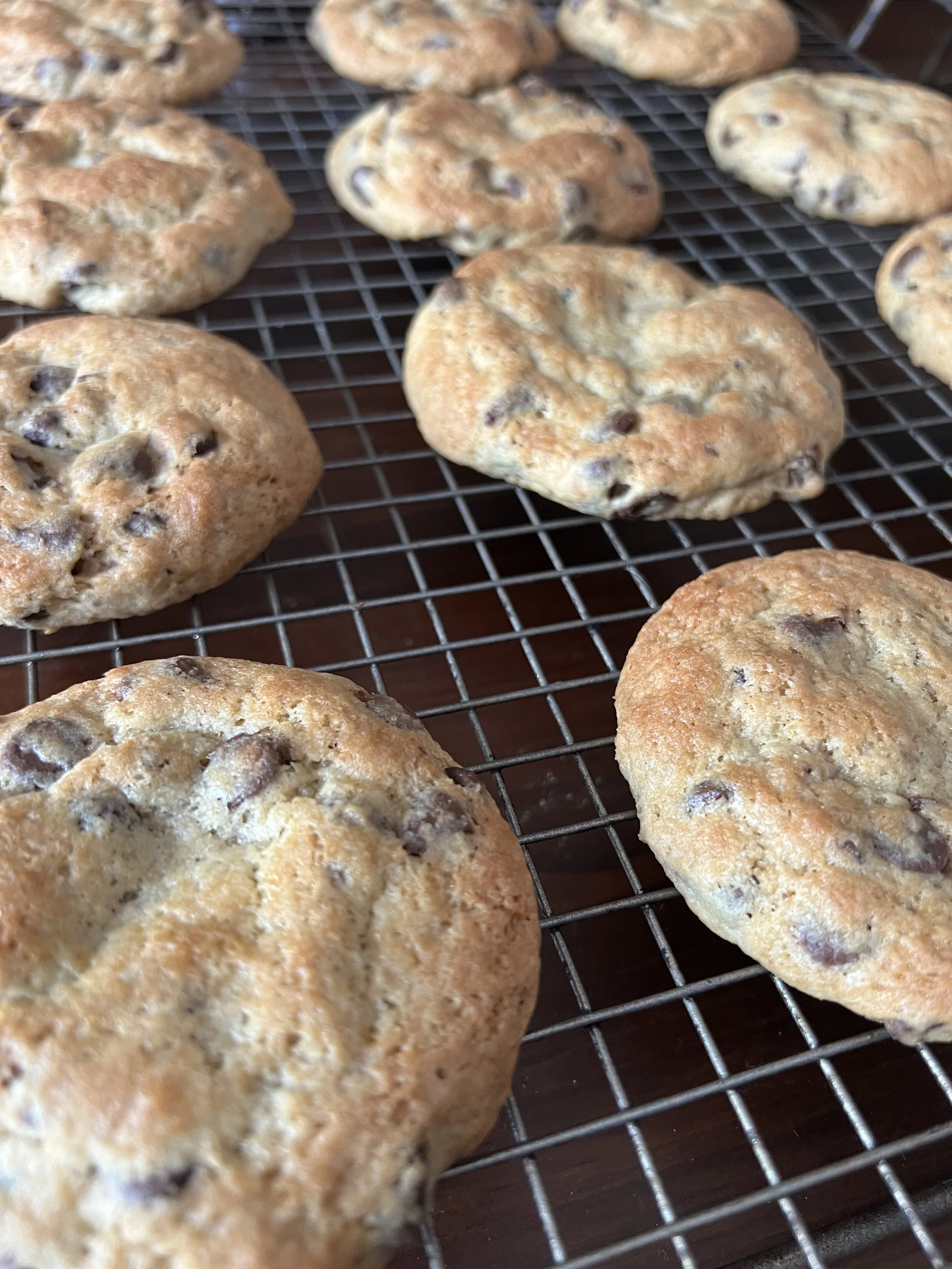 Chocolate chip cookies cooling on a wire rack.