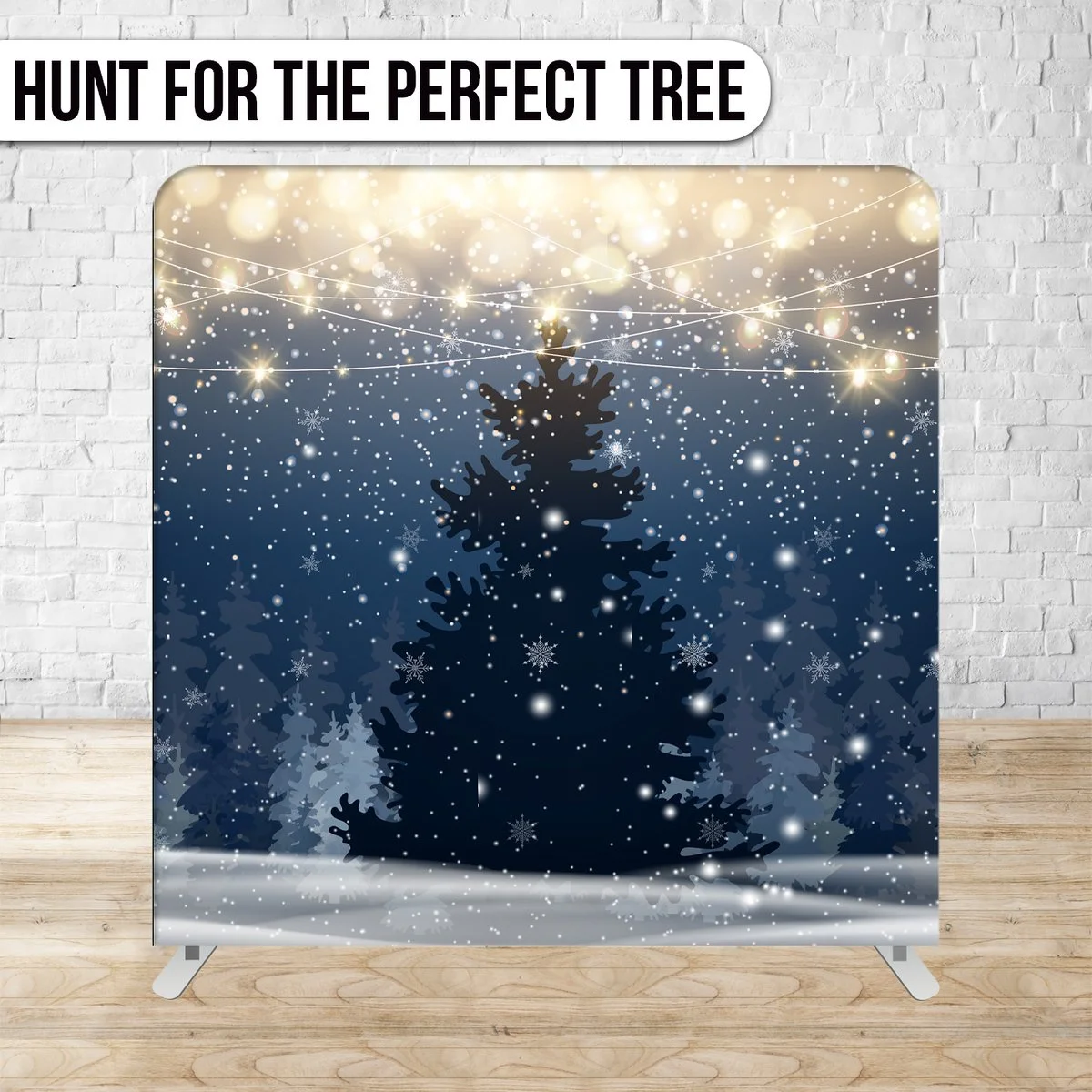 A dark silhouette of a Christmas tree decorated with snowflakes against a wintery background with snow falling and string lights above.