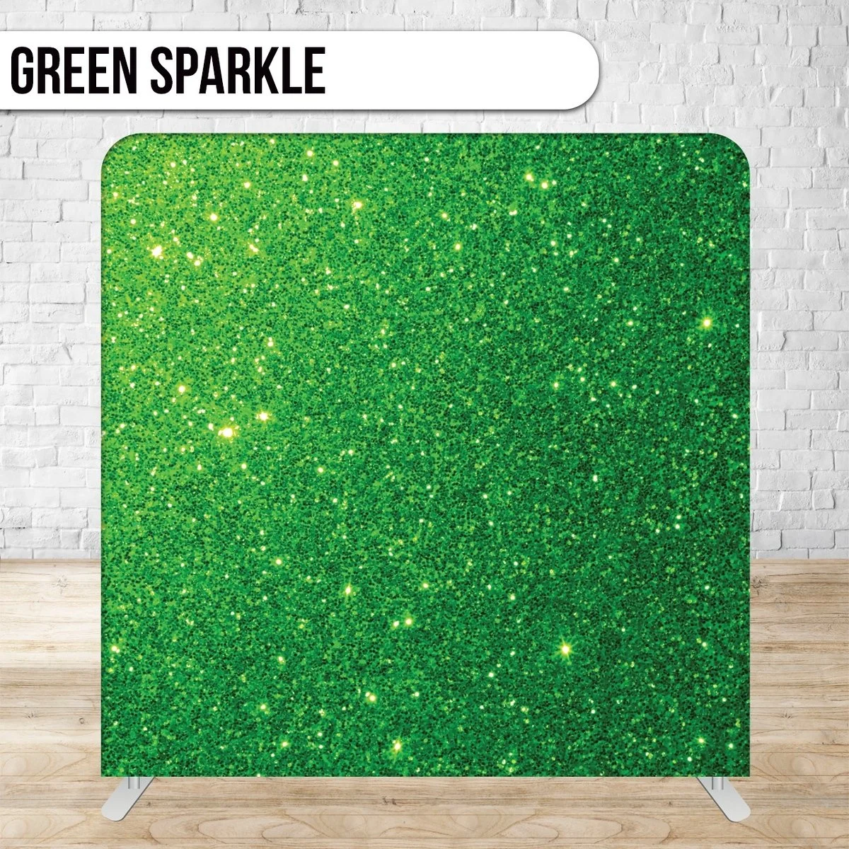 A display stand with green glittery material labeled "Green Sparkle" in black text on a white banner, set against a white brick wall and wooden floor.