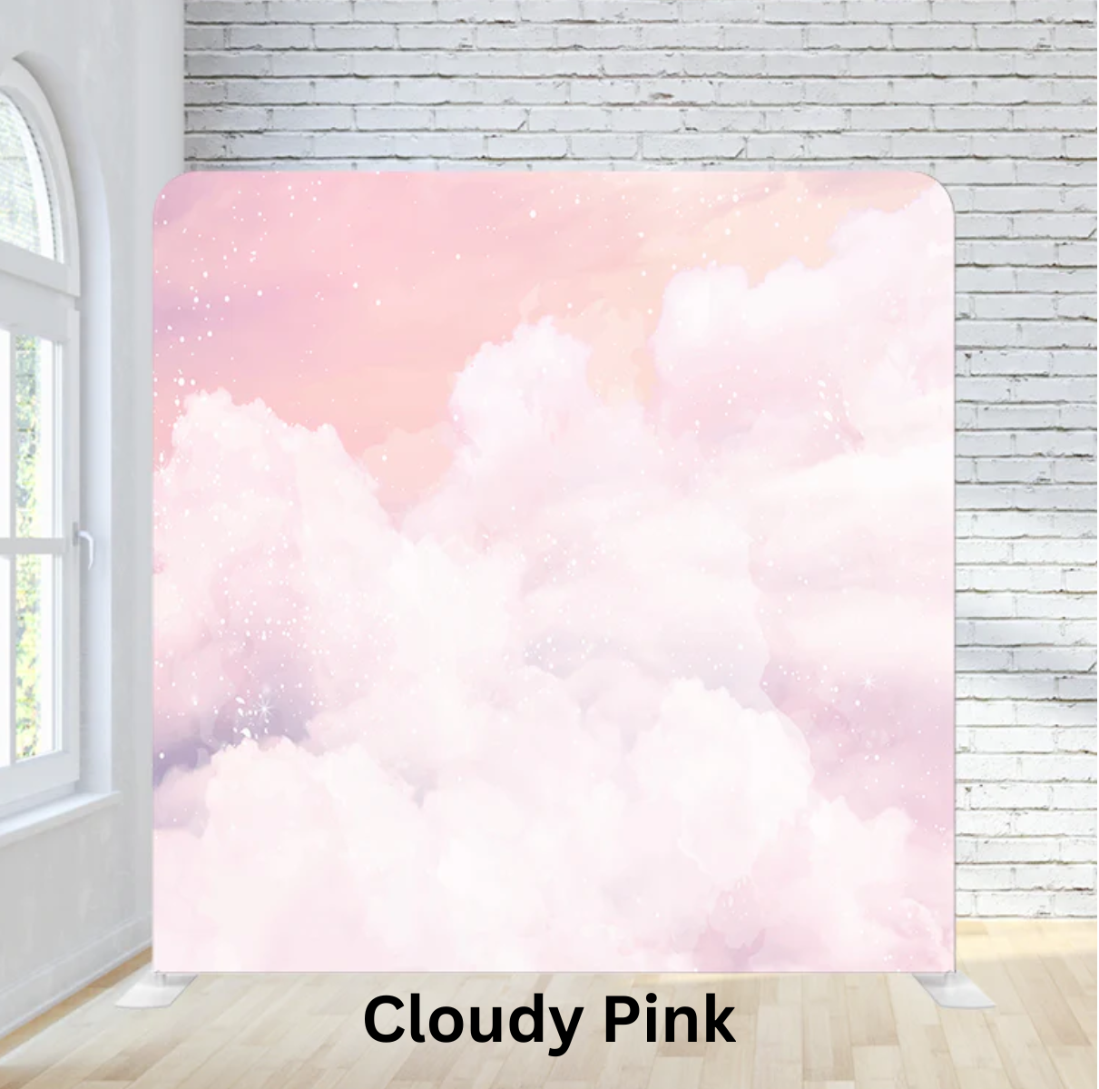 A large pink cloud-themed backdrop with a watercolor sky and stars, set against a white brick wall in a bright room with a window.
