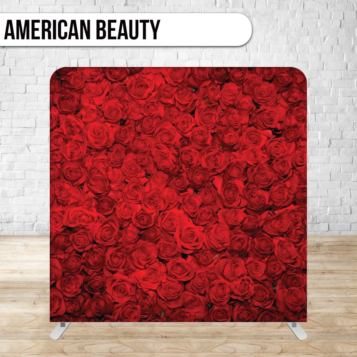A photo of a display or panel covered with red roses, labeled 'American Beauty' at the top, against a white brick wall background.