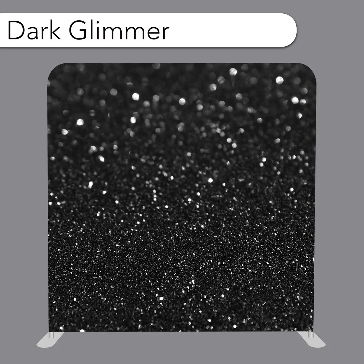 Close-up of a black, glittery, sparkly textured fabric labeled 'Dark Glimmer' on a display board.