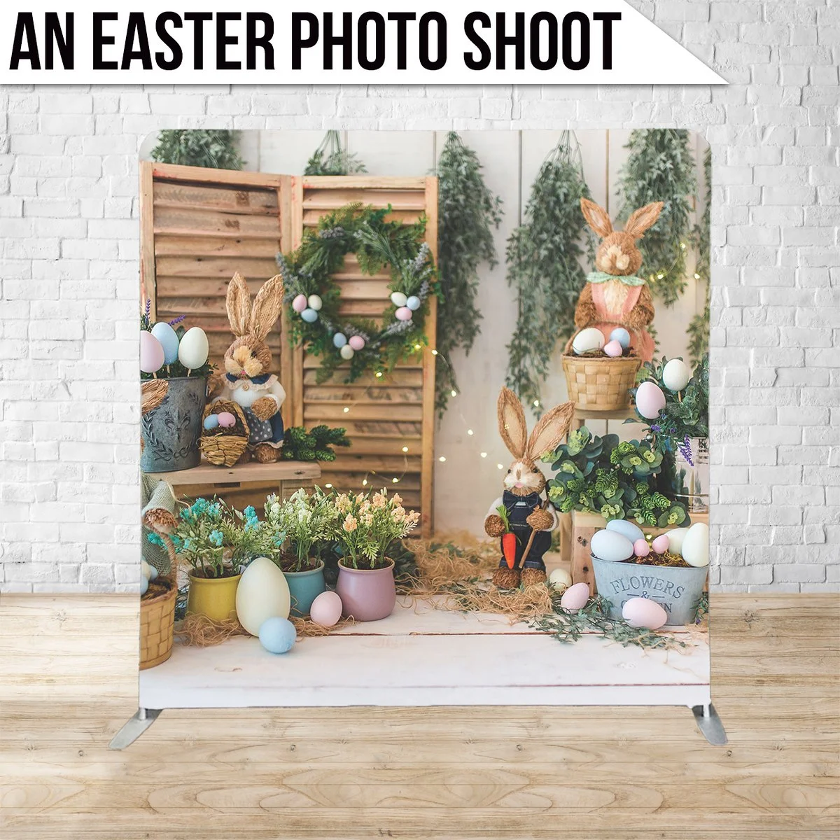 Easter-themed photo shoot setup with bunny plush toys, colorful eggs, flowers, and greenery against a rustic backdrop.