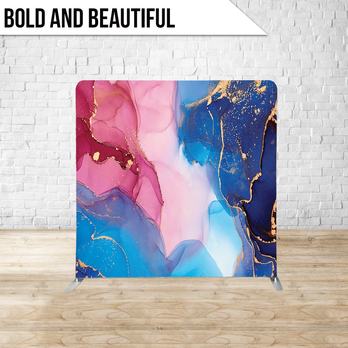 Abstract art with pink, blue, and navy colors with gold accents, displayed as a divider or backdrop against a white brick wall.