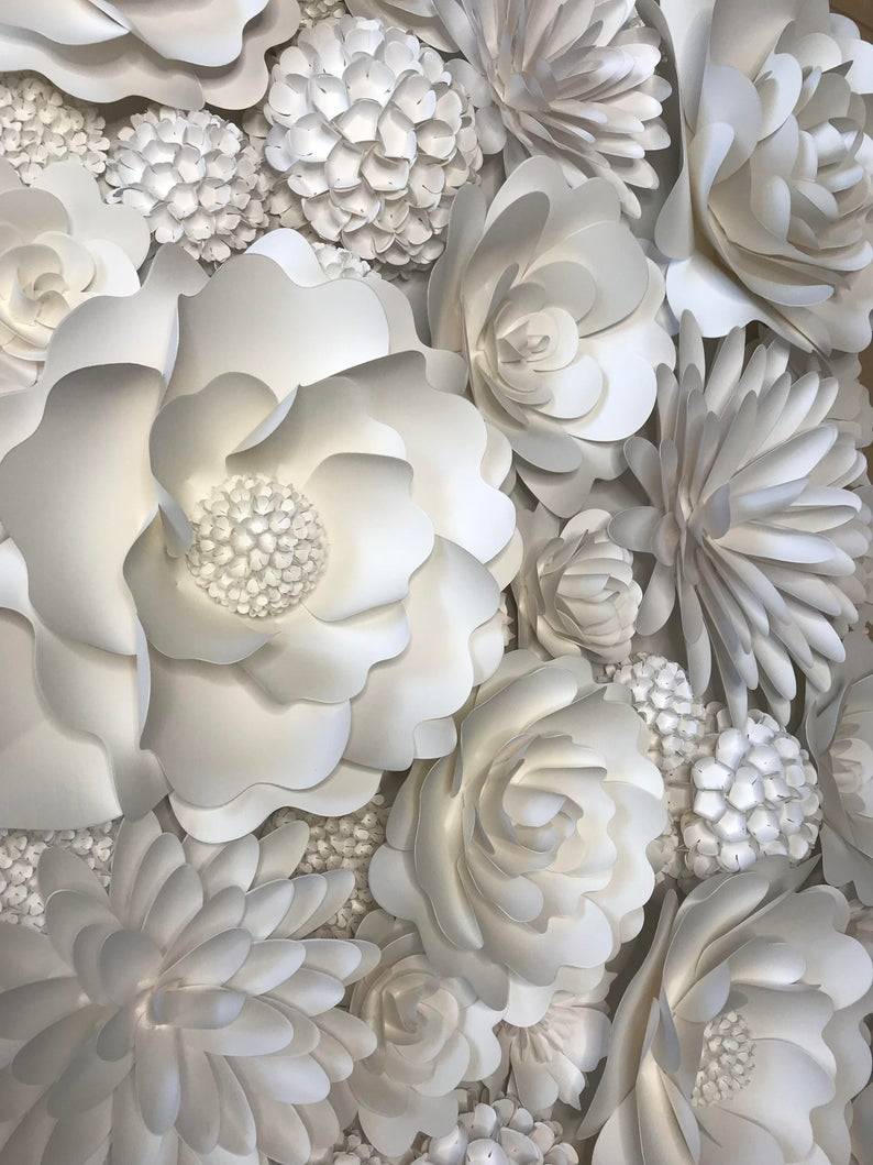 White decorative wall covering with large 3D paper flowers and floral patterns arranged in a clustered design.