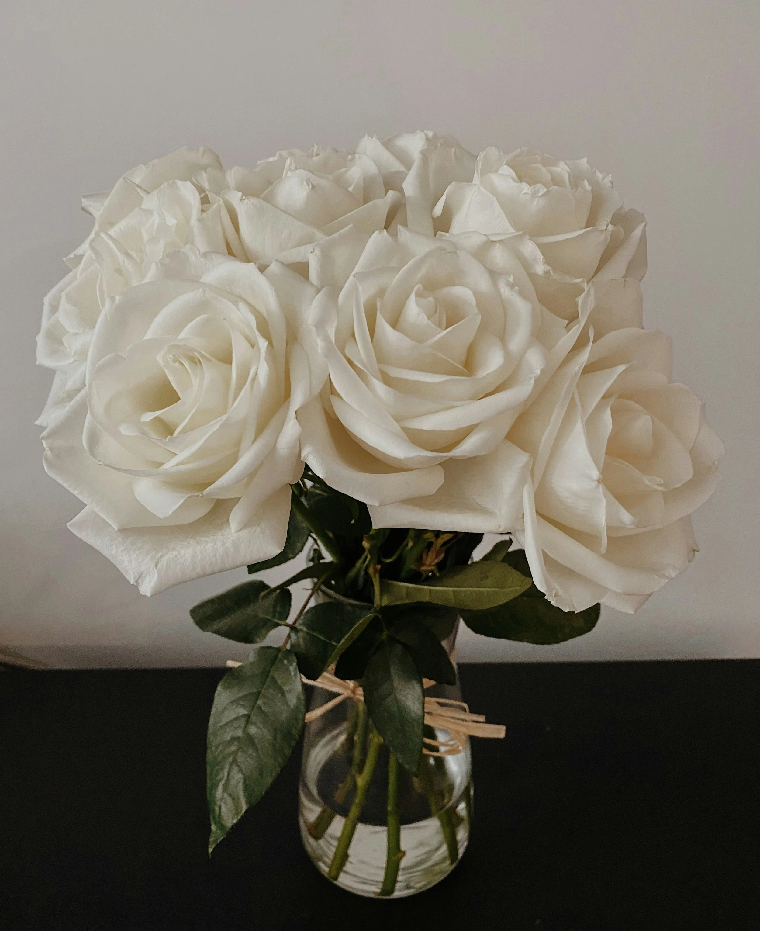 A bouquet of white roses in a glass vase.