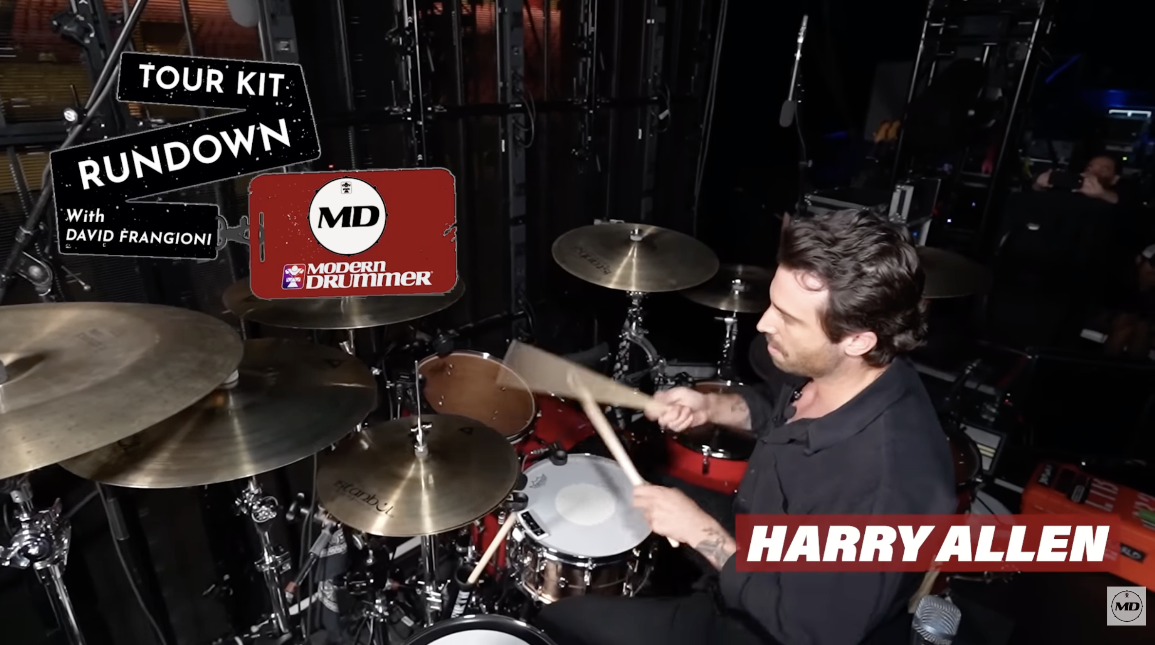 Harry Allen playing drums in a studio setting, with multiple drums and cymbals, and graphic overlays displaying 'Tour Kit Rundown with David Frangioni', 'Modern Drummer', and 'Harry Allen'.