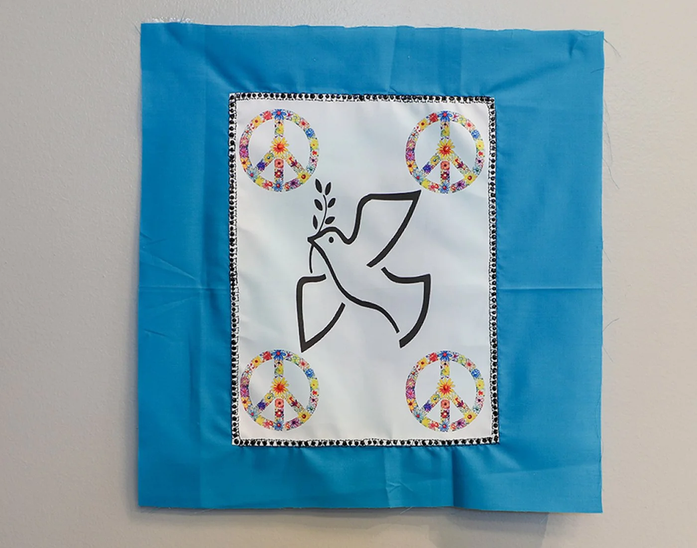 SYMBOLS OF PEACE
The image includes a Peace Dove and four peace signs to convey a message of Peace. “Peace” as represented by the traditional symbols of a dove with olive branch and flowering peace symbols reminded me of the 1970s. This Vietnam War t
