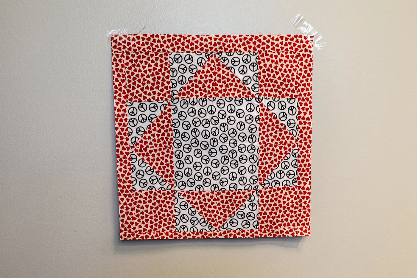 GEOMETRY OF PEACE AND LOVE
I began quilting over a year ago. When MJJ said “Love and Peace”, I immediately identified the perfect fabric from quilts I’d made! A leftover piece with the peace symbol (black and white) and another with hearts (red on wh