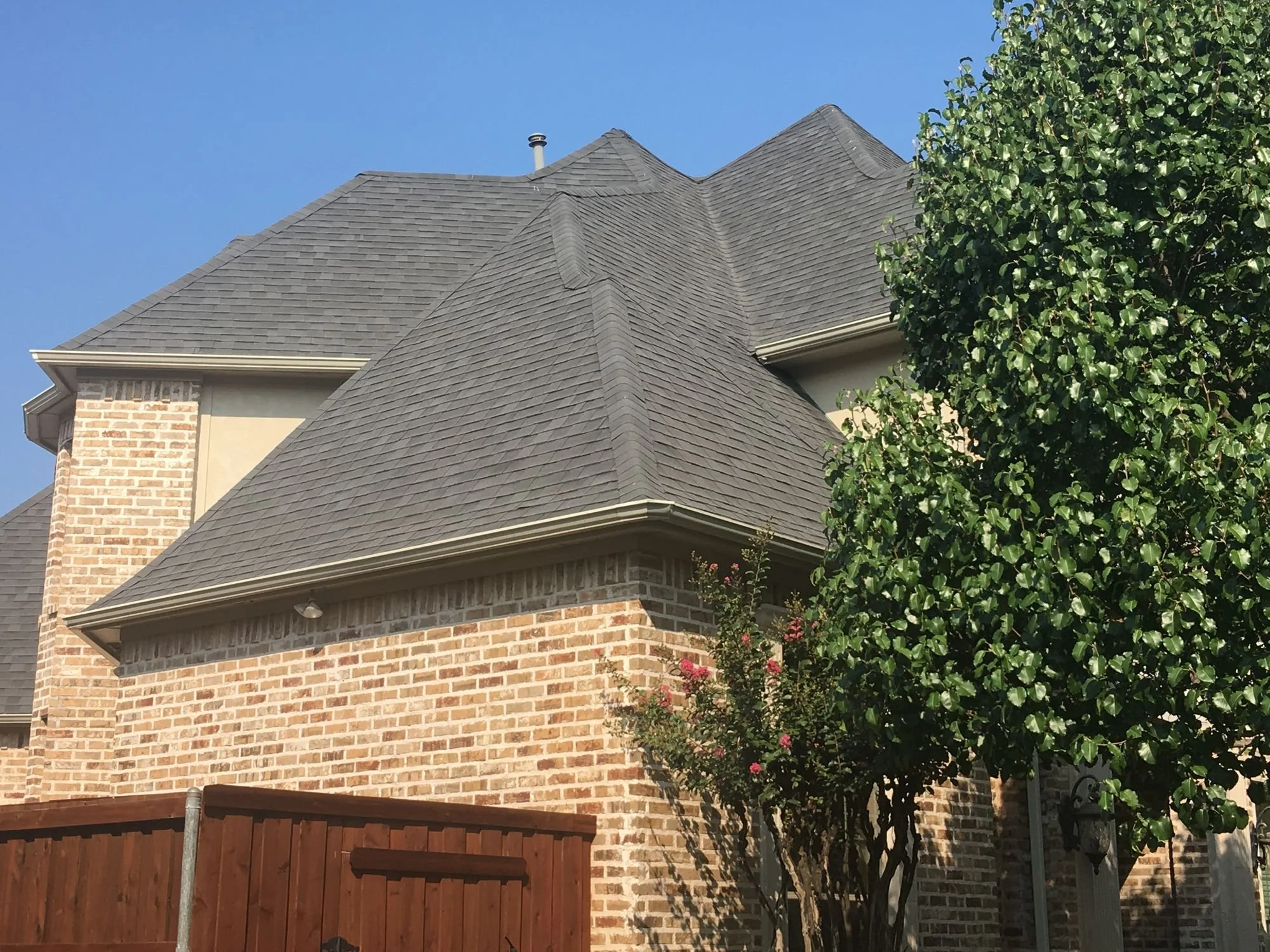 New gray shingle roof on a brick home in Frisco, TX by Christian Brothers Roofing