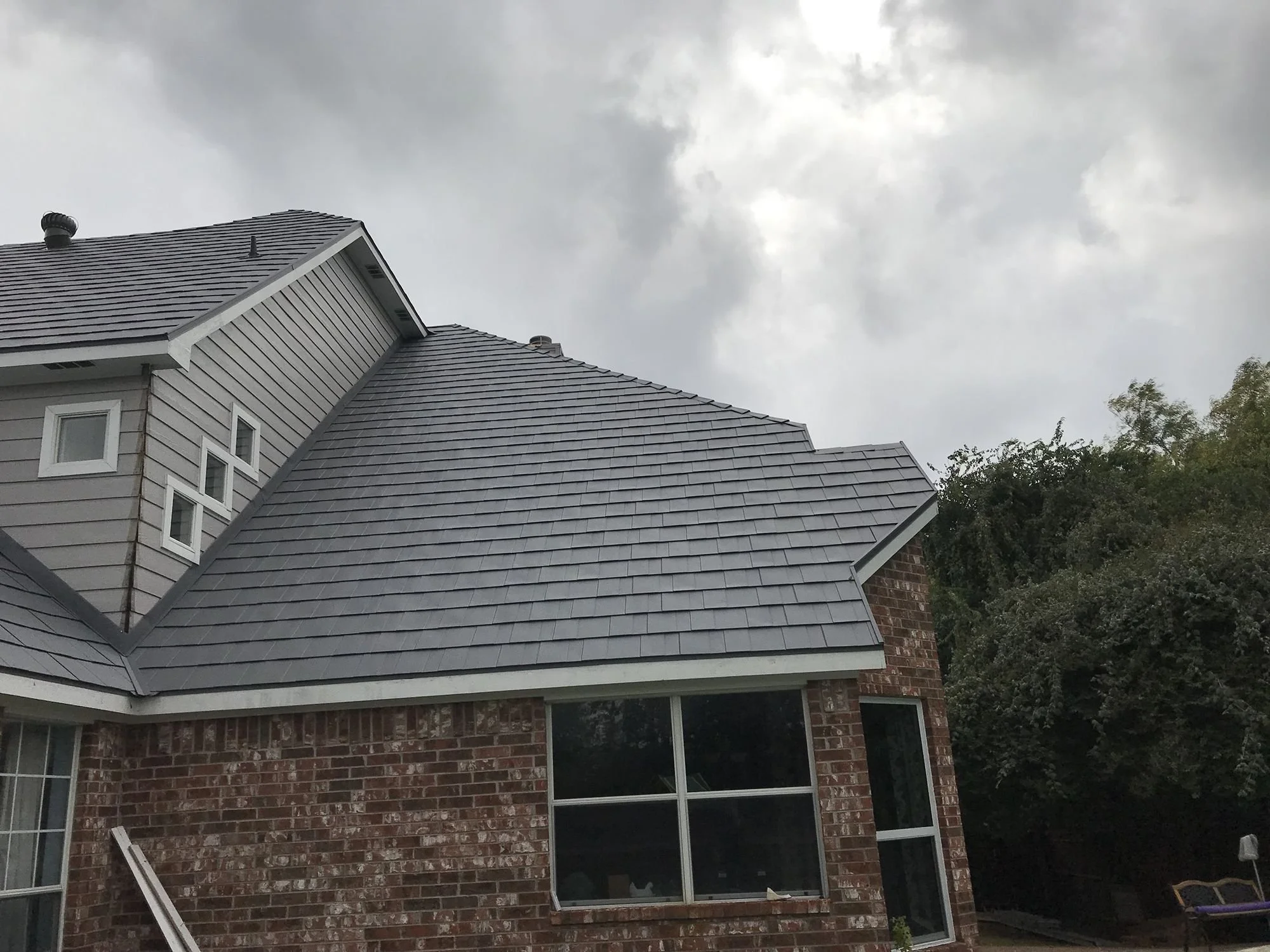 Brick home with a new gray shingle roof by Christian Brothers Roofing in Dallas-Fort Worth
