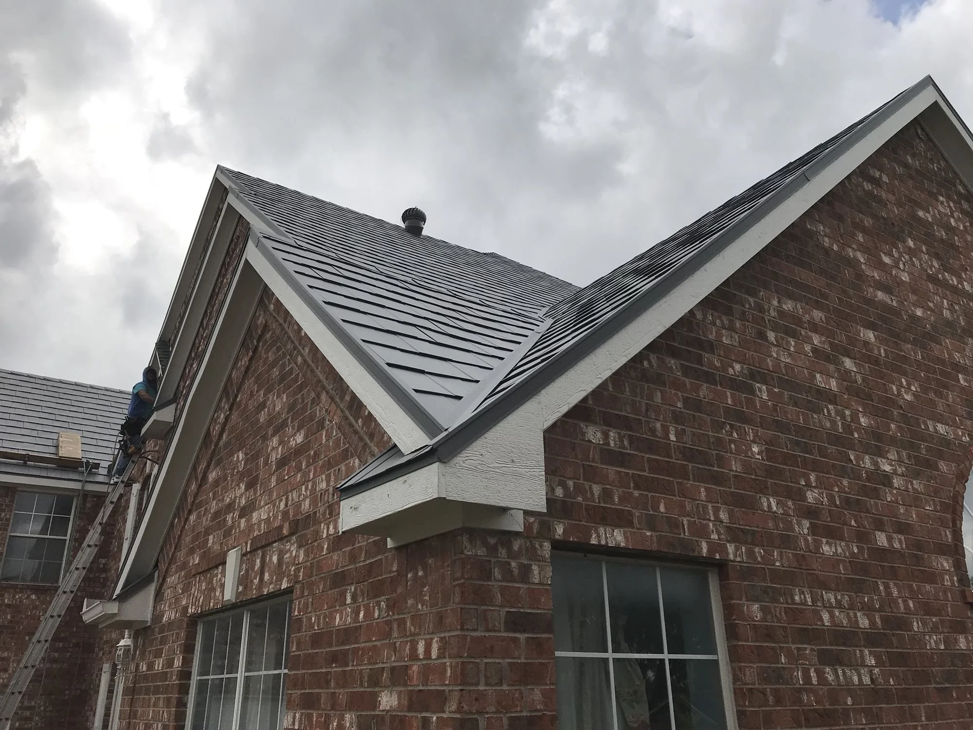 Brick home with a new gray shingle roof by Christian Brothers Roofing in North Texas
