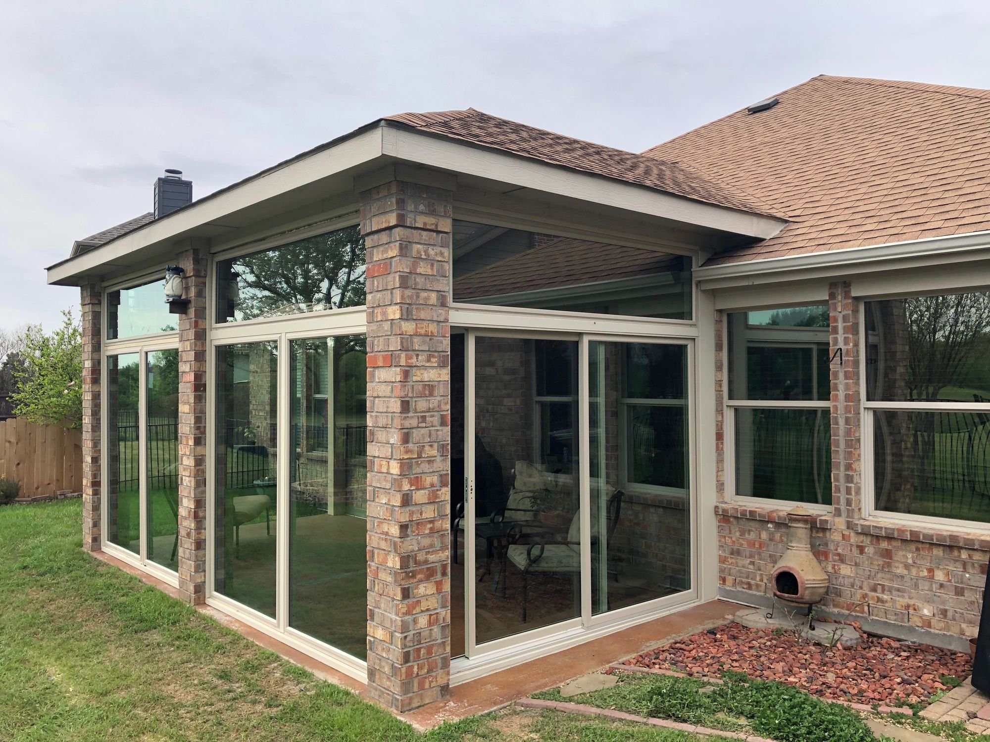 Enclosed patio addition with a shingle roof on a McKinney, TX home by Christian Brothers Roofing