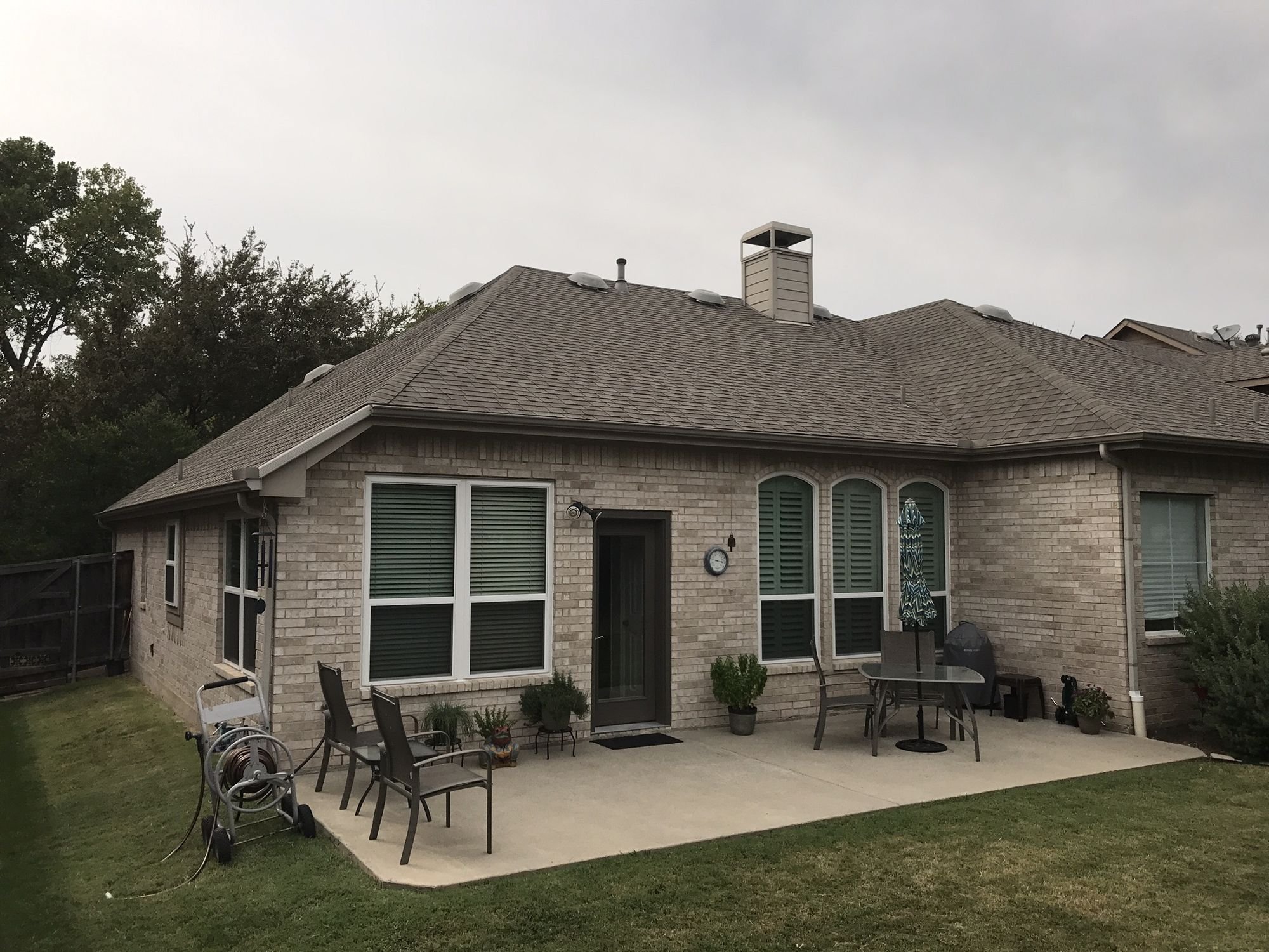 Brick home with a new shingle roof by Christian Brothers Roofing in North Texas
