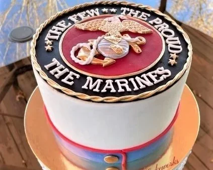 A round cake featuring the United States Marine Corps emblem with the words 'Semper Fi** The Proud The Marines' on top.