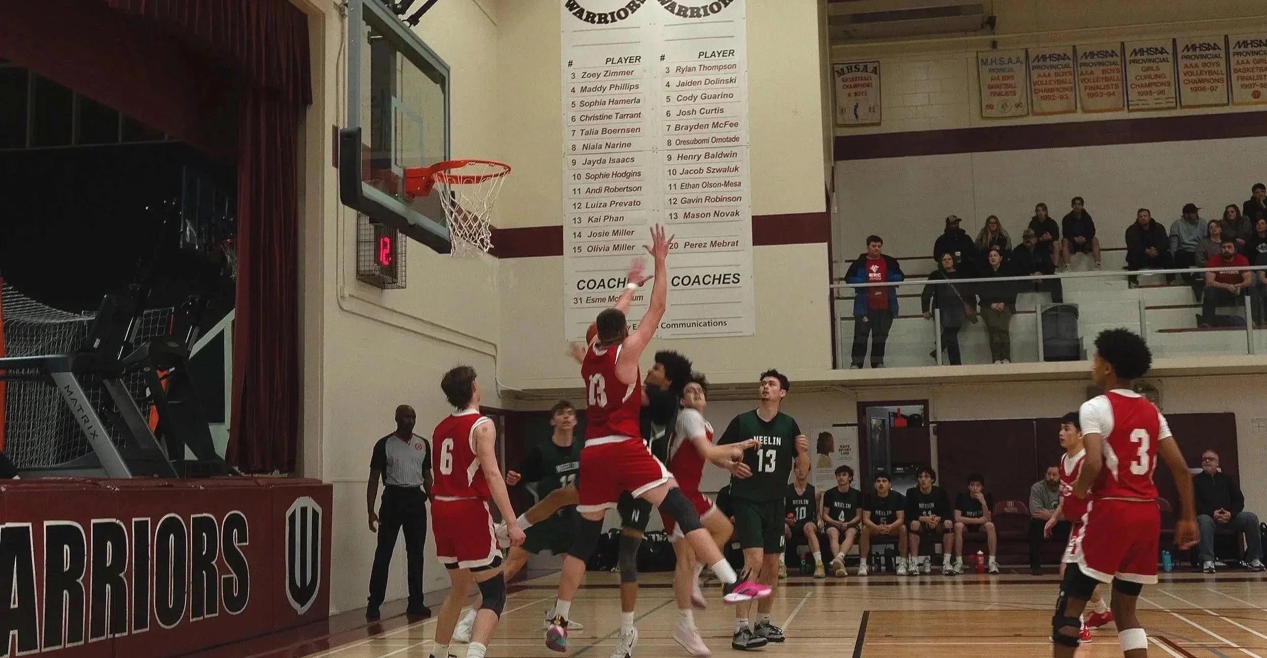 A highschool boy's basketball game, one boy is trying to dunk, the other stopping him