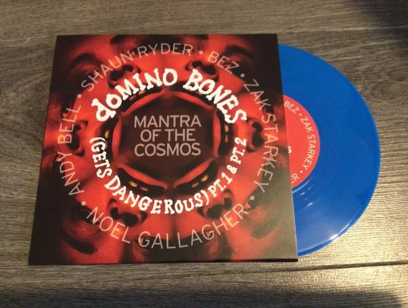 Blue vinyl record and album cover titled "Mantra of the Cosmos" with circular text and red abstract design.