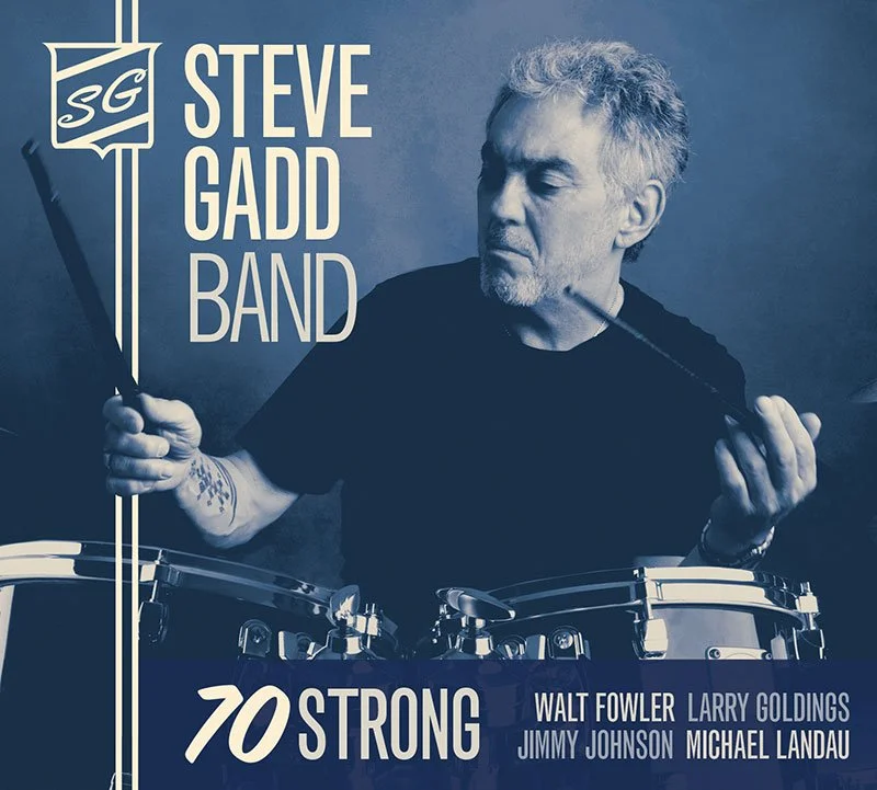 Album cover featuring Steve Gadd Band with a monochrome portrait of Steve Gadd holding drumsticks, text indicating album title '70 Strong' and featuring artists Walt Fowler, Larry Goldings, Jimmy Johnson, and Michael Landau.