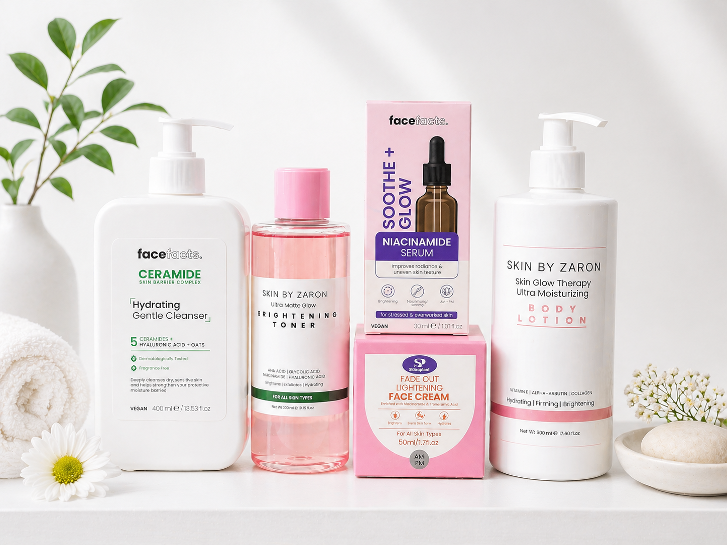 Collection of skincare products including a face cleanser, toner, face serum, face cream, and body lotion arranged on a white surface with decorative plants and flowers in a minimalistic setting.