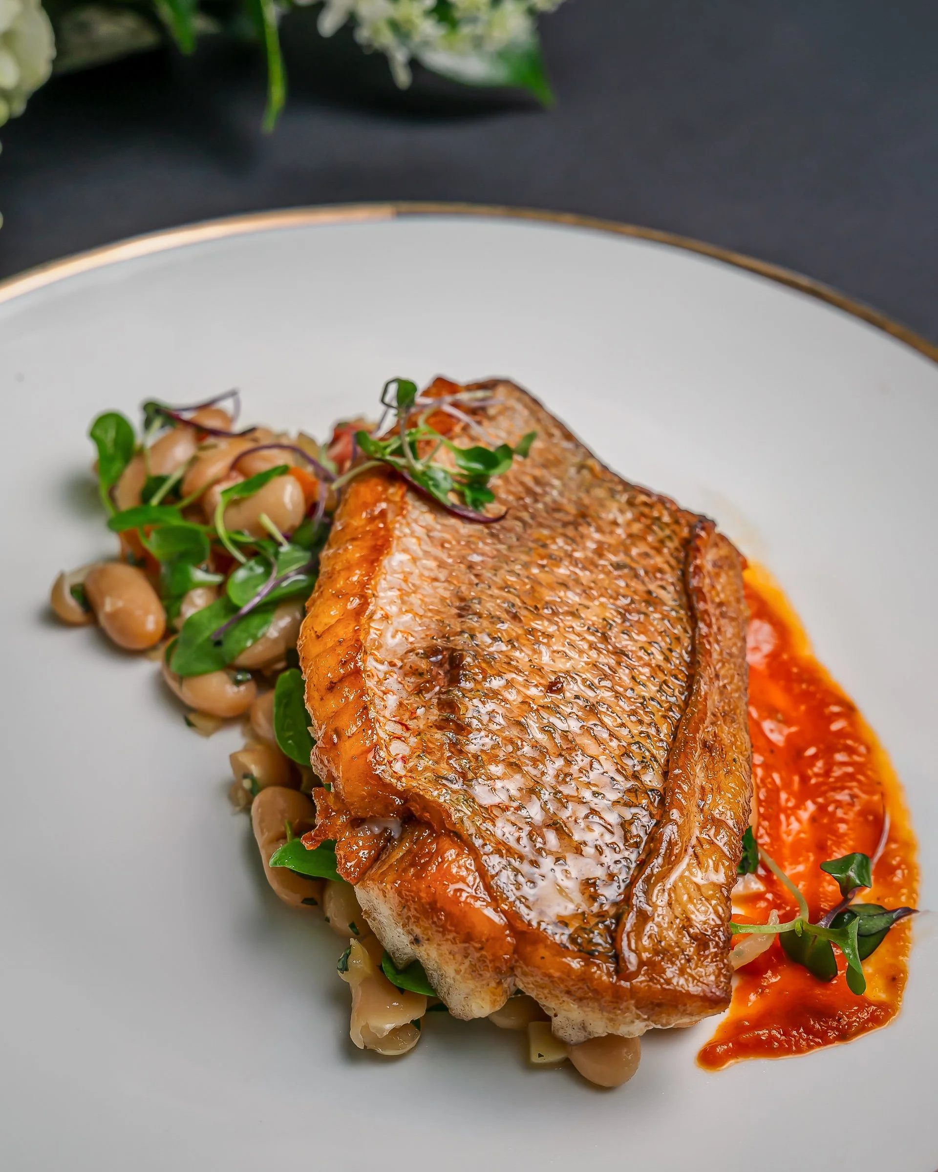 Miami food photography of a plated fish dish with crispy skin, styled for restaurant menus and branding.
