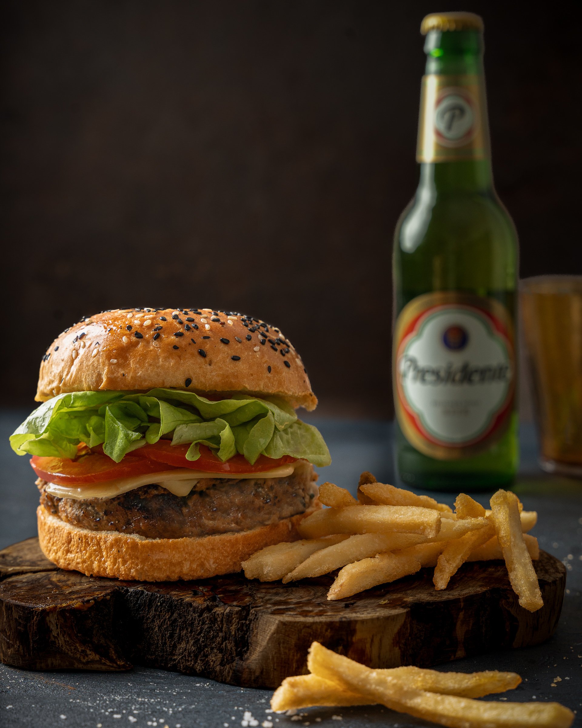 The Classic Burger Duo | Food & Beverage Photography
stunning editorial shot of a classic beef burger and French fries served on a rustic wooden board. Captured with professional depth of field to emphasize the layers of fresh ingredients and cold be