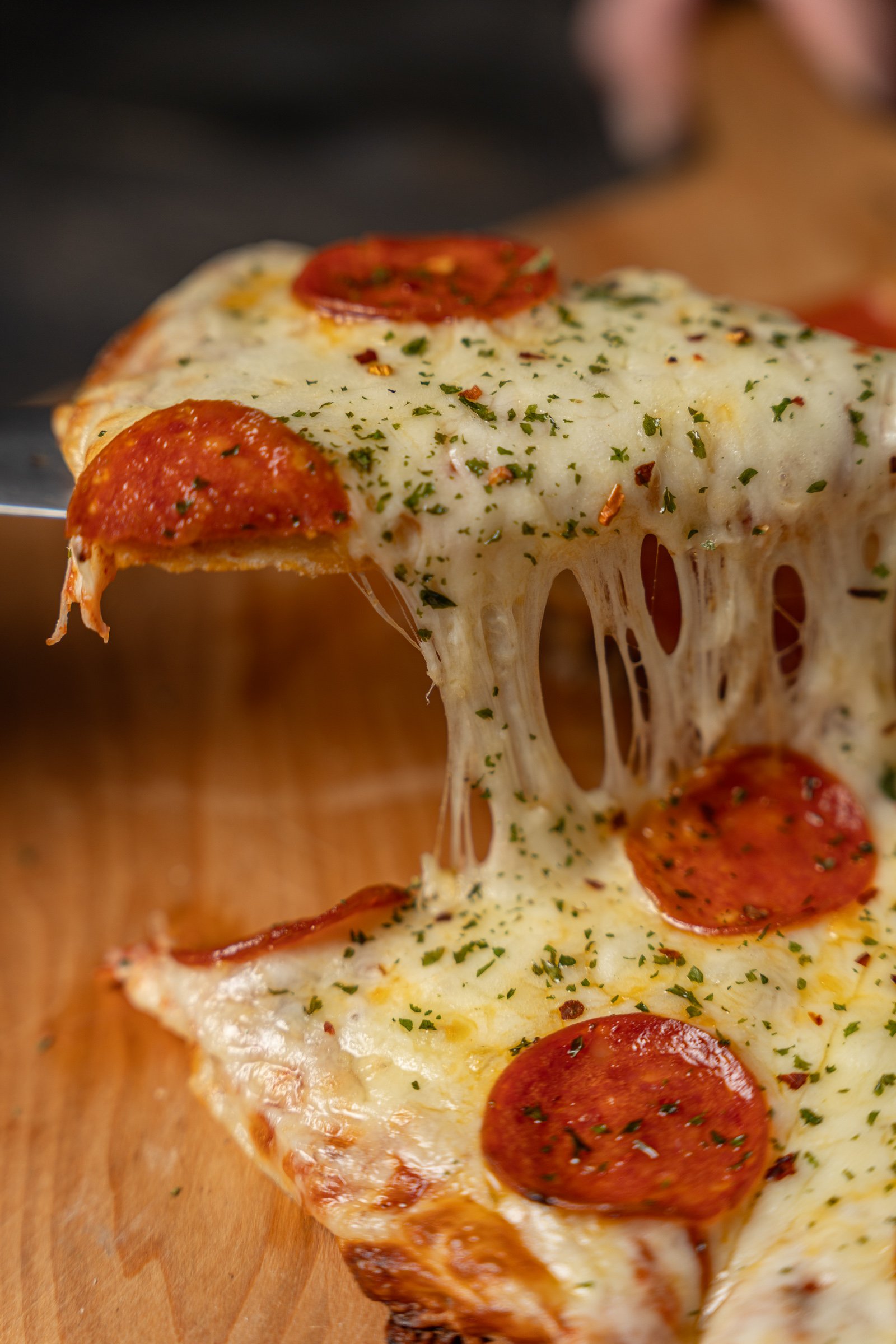 Pizza de Pepperoni: El "Cheese Pull" Perfecto
Fotografía publicitaria de una rebanada de pizza de pepperoni con un efecto de queso derretido (cheese pull) dinámico. La imagen destaca los ingredientes frescos, especias y una textura irresistible, capt