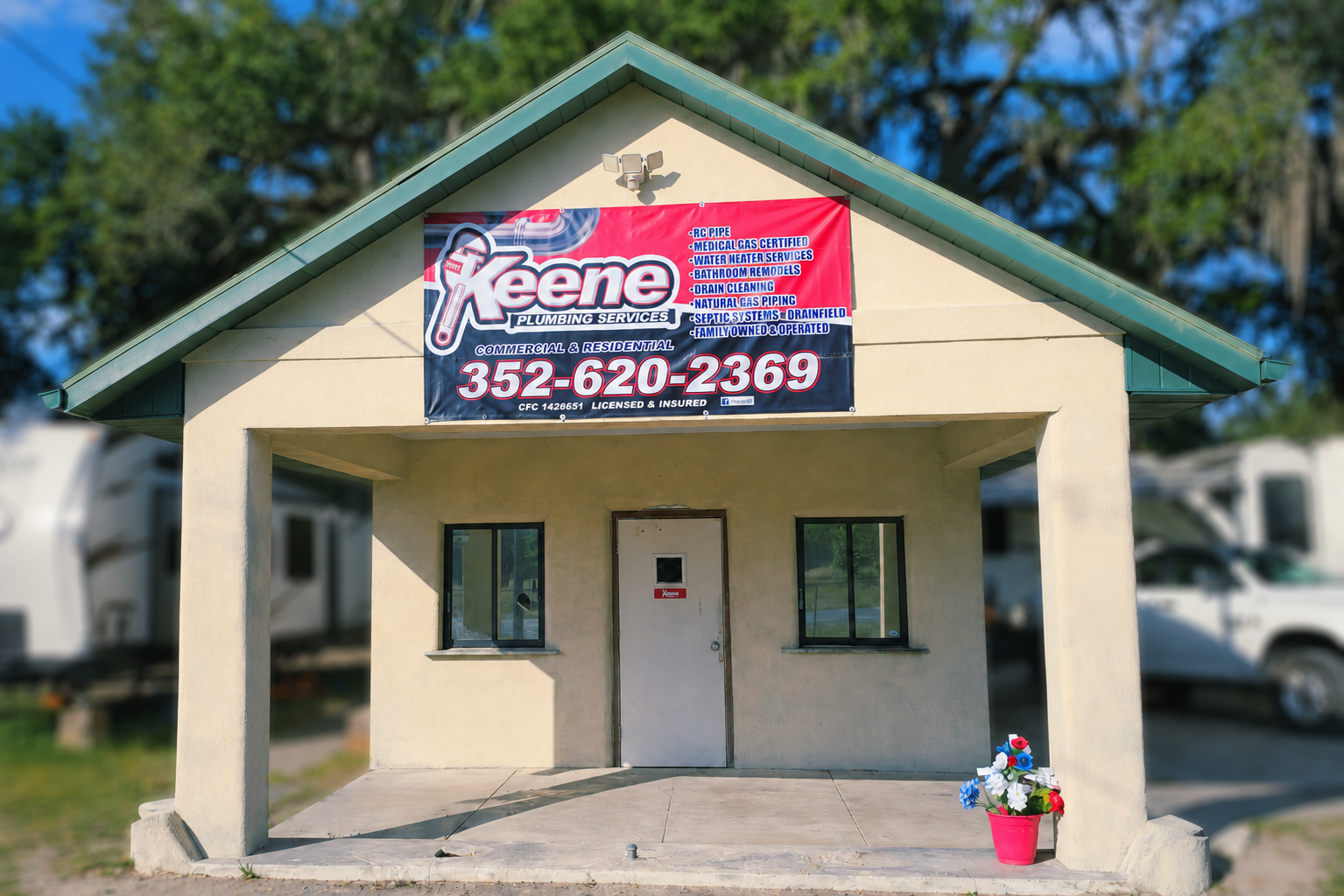Front exterior of Keene Plumbing Services commercial plumbing office in Williston, Florida with company signage and service building entrance.