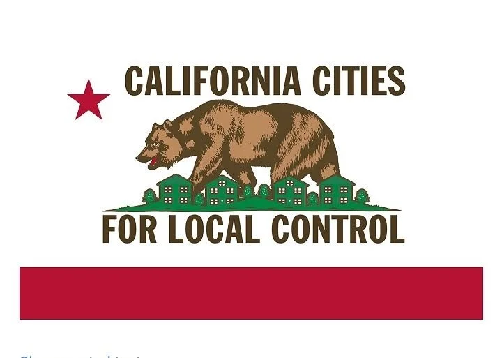 A campaign sign with a bear walking over small city buildings, a red star, and the text 'California Cities for Local Control'.